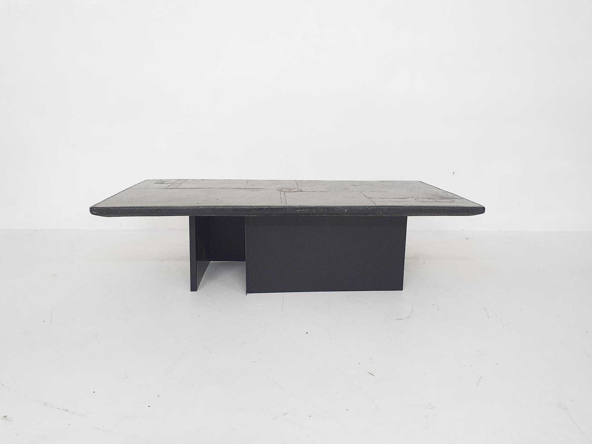 Stone coffee table on two L-shaped metal plates. We think it is the design of Marcus or Paul Kingma, only the top has no mark.