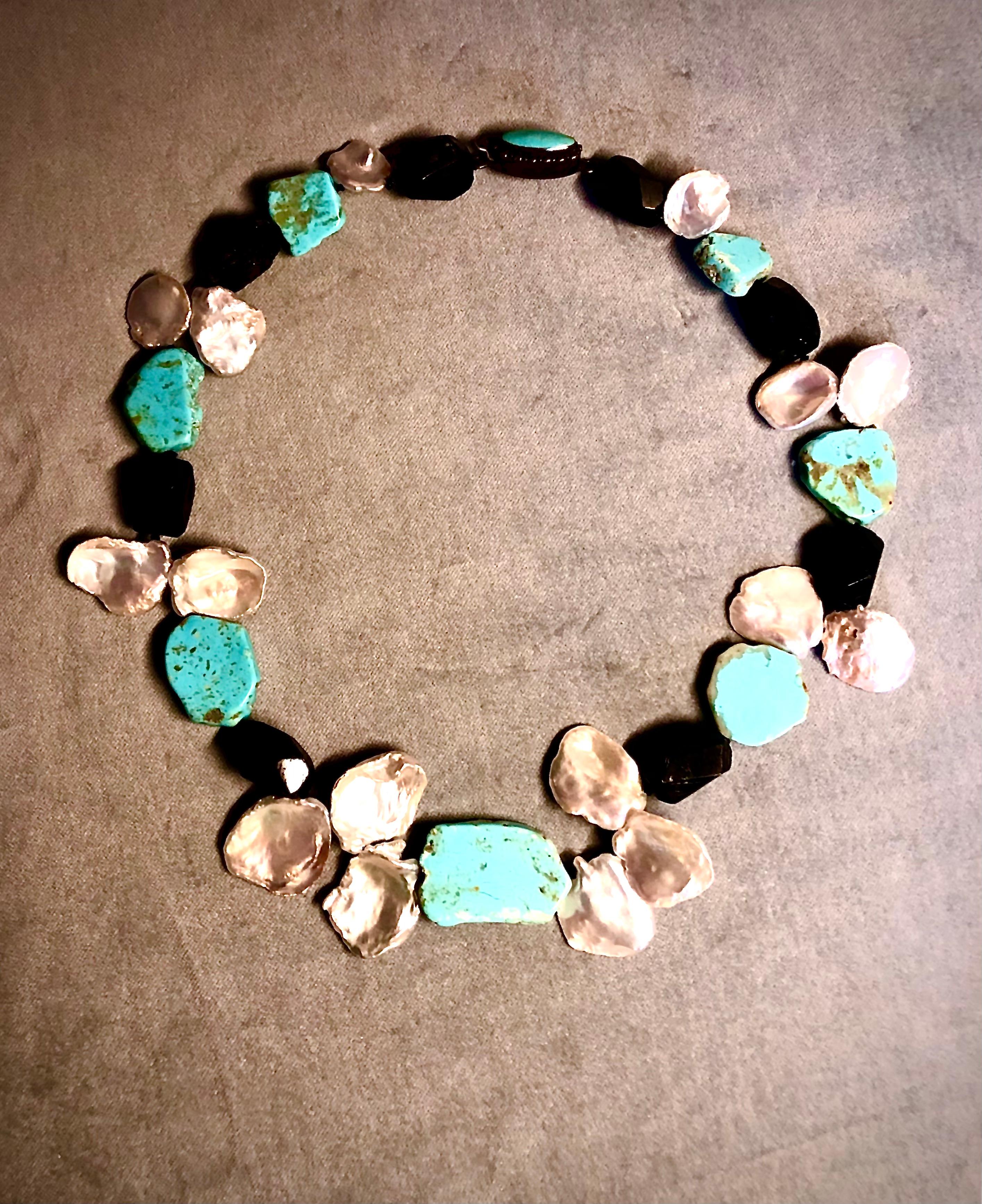 Bold statement necklace of richly colored Kingman turquoise slabs interspersed with chunky tumbled tourmaline beads and very large baroque Keshi fan pearls. The necklace terminates in a lovely finely detailed box clasp set with turquoise in oxidized
