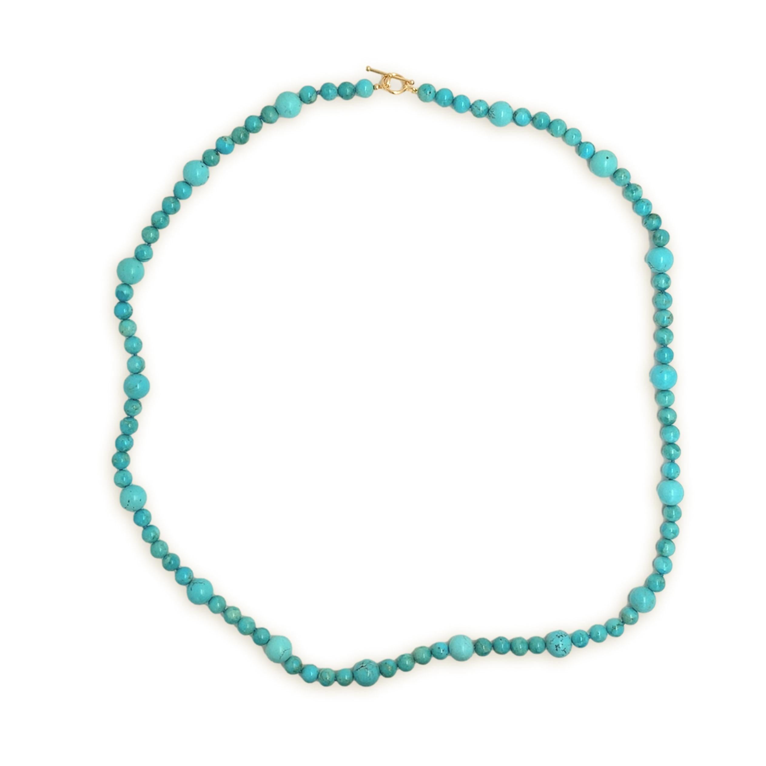 Un fil de turquoises américaines avec de grosses turquoises Kingman de 11-12 mm alternant avec des turquoises Kingman de 8-9 mm.  Les perles ont une couleur bleu-turquoise. Il y a quelques veines de couleur beige à brune. Les perles sont taillées en