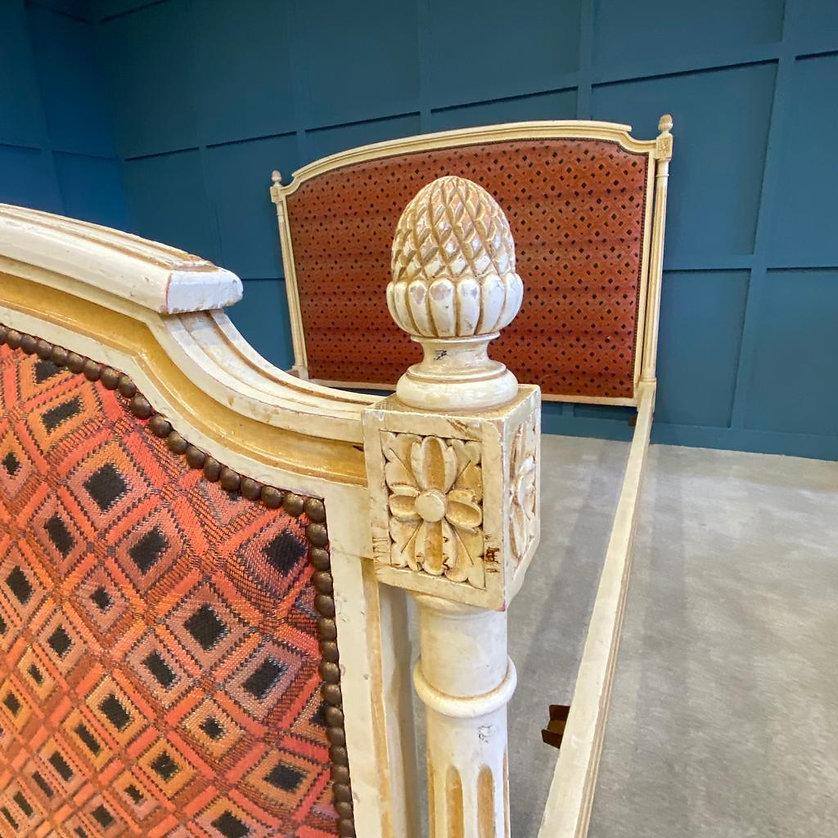Louis XV1 Style French upholstered bed with decorative columns on the head and foot end. The frame has carved pineapple bed knobs and pretty flower detailing on the corner sections.
 
The bed will be newly painted and upholstered in your choice of