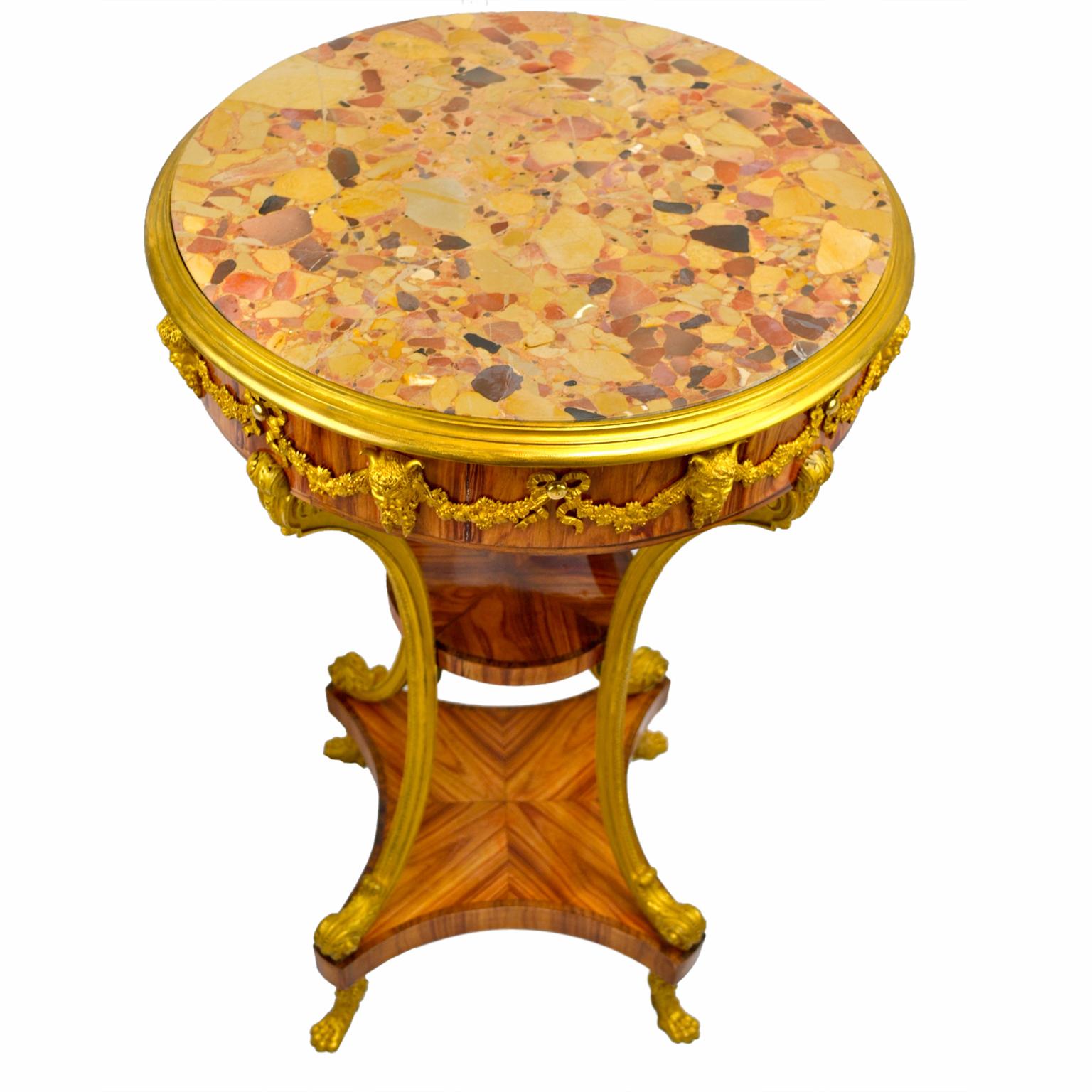 Table d'appoint/de centre ronde très décorative de style Louis XVI ; le plateau en marbre Brèche d'Alp a une bordure en bronze doré au-dessus d'une jupe en bois de tulipier décorée en ronde avec des masques de satyre et des guirlandes dorés ; quatre