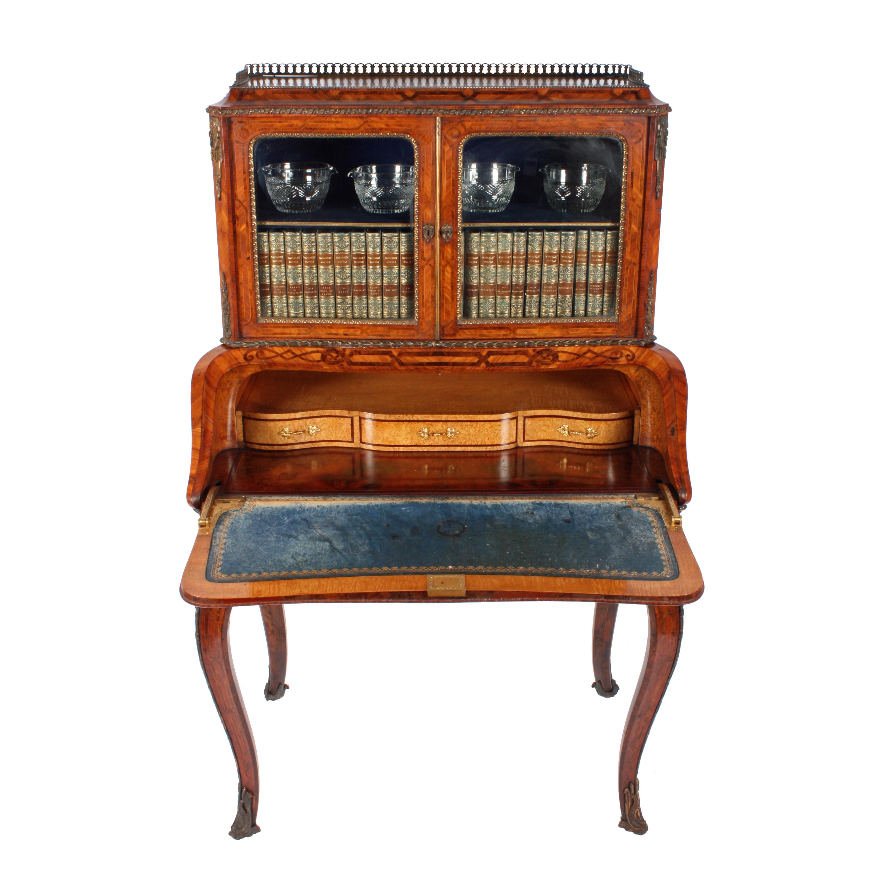 A 19th century Victorian bombé shaped bureau with a cabinet top.

The bureau is quarter veneered in kingwood and is parquetry inlaid with figured walnut.

The bureau has gilt metal mounts and stands on four cabriole shaped legs.

The shaped