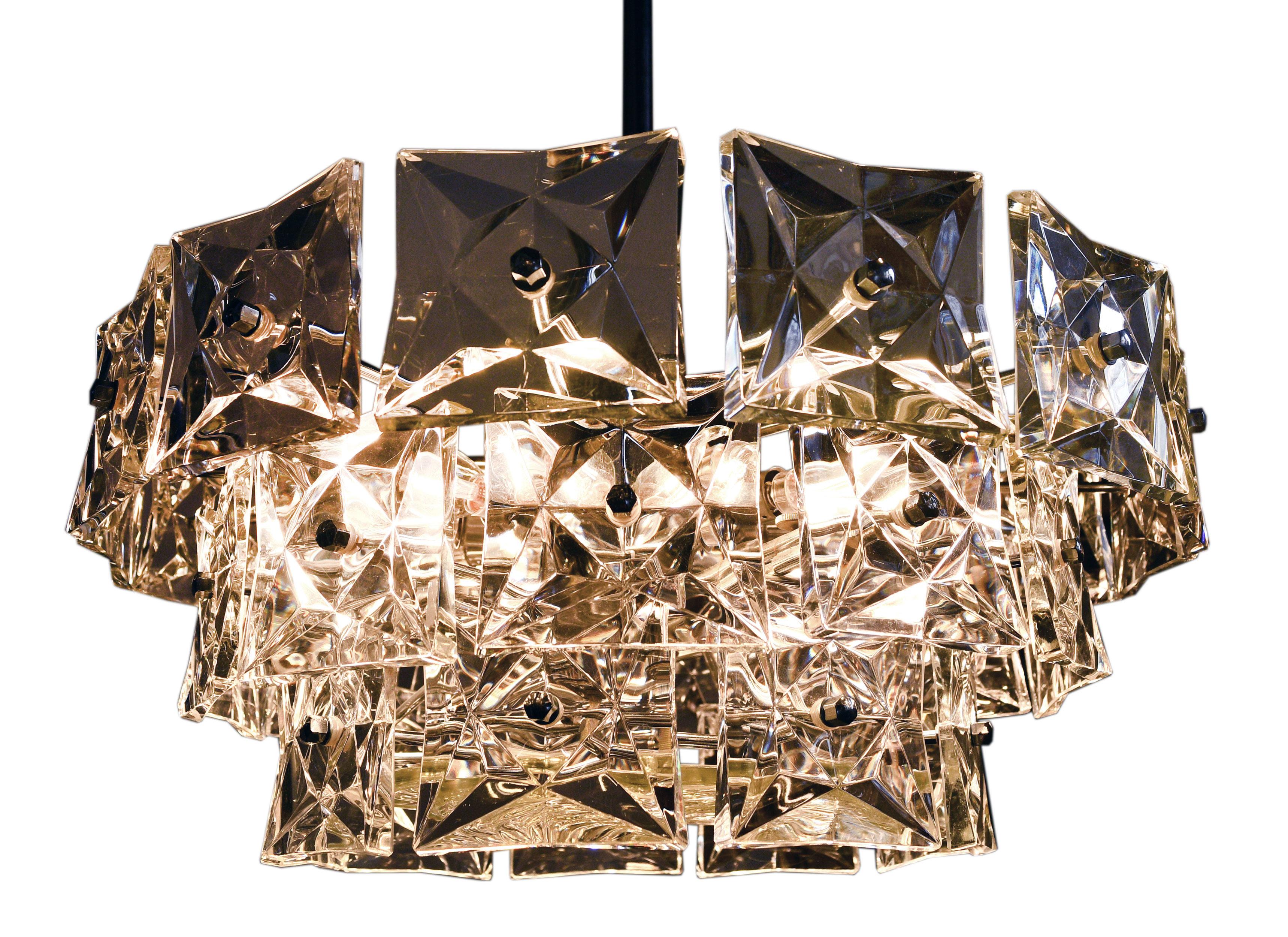 This stunningly crafted Kinkeldey chandelier features 3 levels of lovely hanging crystals and gives off warm glow when illuminated. Kinkeldey manufactured high end lighting fixtures in the 1960s and 1970s. The high-quality glass crystals can be