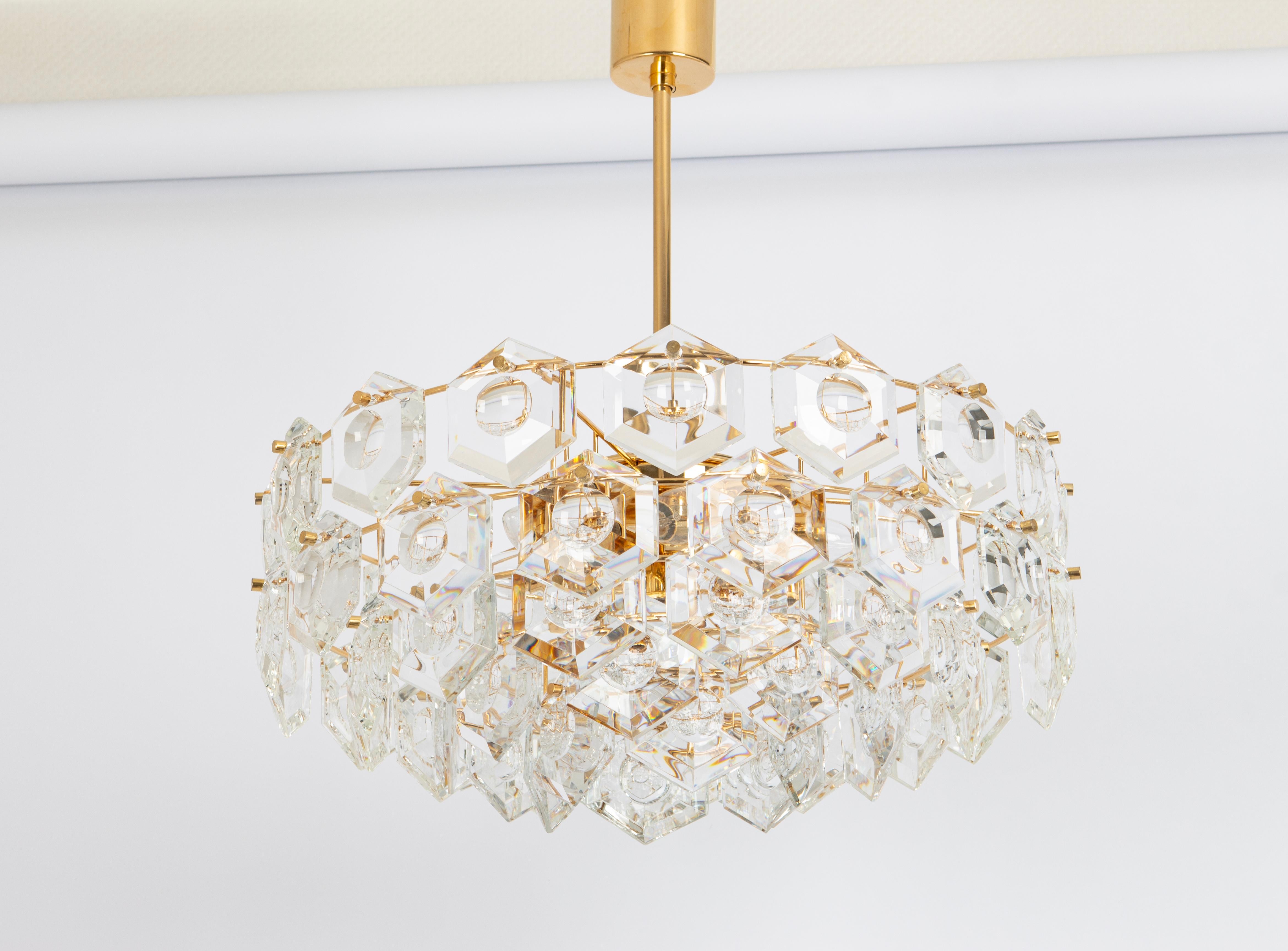 A stunning five-tier chandelier by Kinkeldey, Germany, manufactured in circa 1970-1979. A handmade and high quality piece. The chandelier features a 24-karat gold-plated four-tier structure with lots of facetted crystal glass elements.

High quality