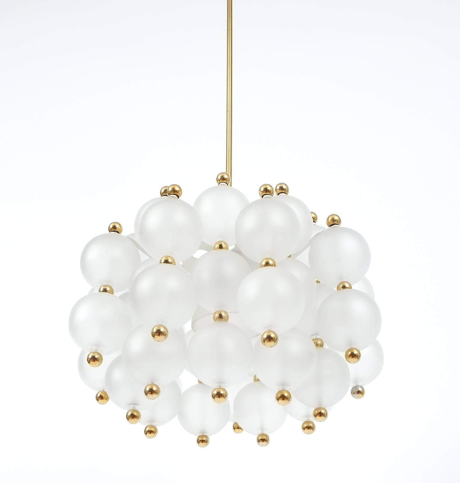 Large opaline glass chandelier by Kinkeldey, Germany, late mid-century.

Glass chandelier by Kinkeldey, circa 1980. Beautiful and large chandelier with a multitude of smooth translucent handblown glass balls with golden brass knobs. The fixture is
