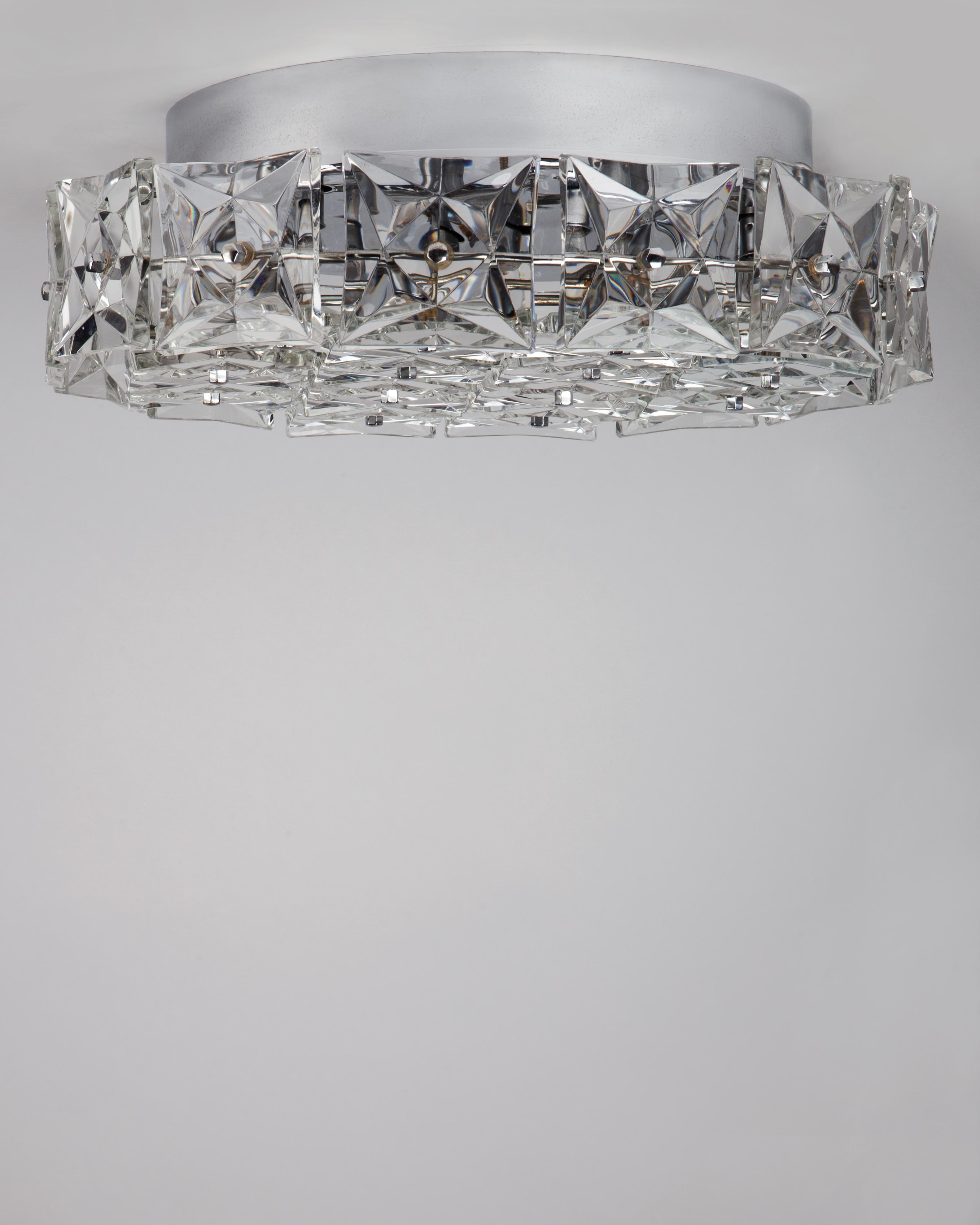 AHL4055
A vintage Mid-Century flush mount with squares of thick clear faceted glass held on a round frame in its original chrome finish. Signed by the Austrian maker Kinkeldey. Due to the antique nature of this fixture, there may be some nicks or