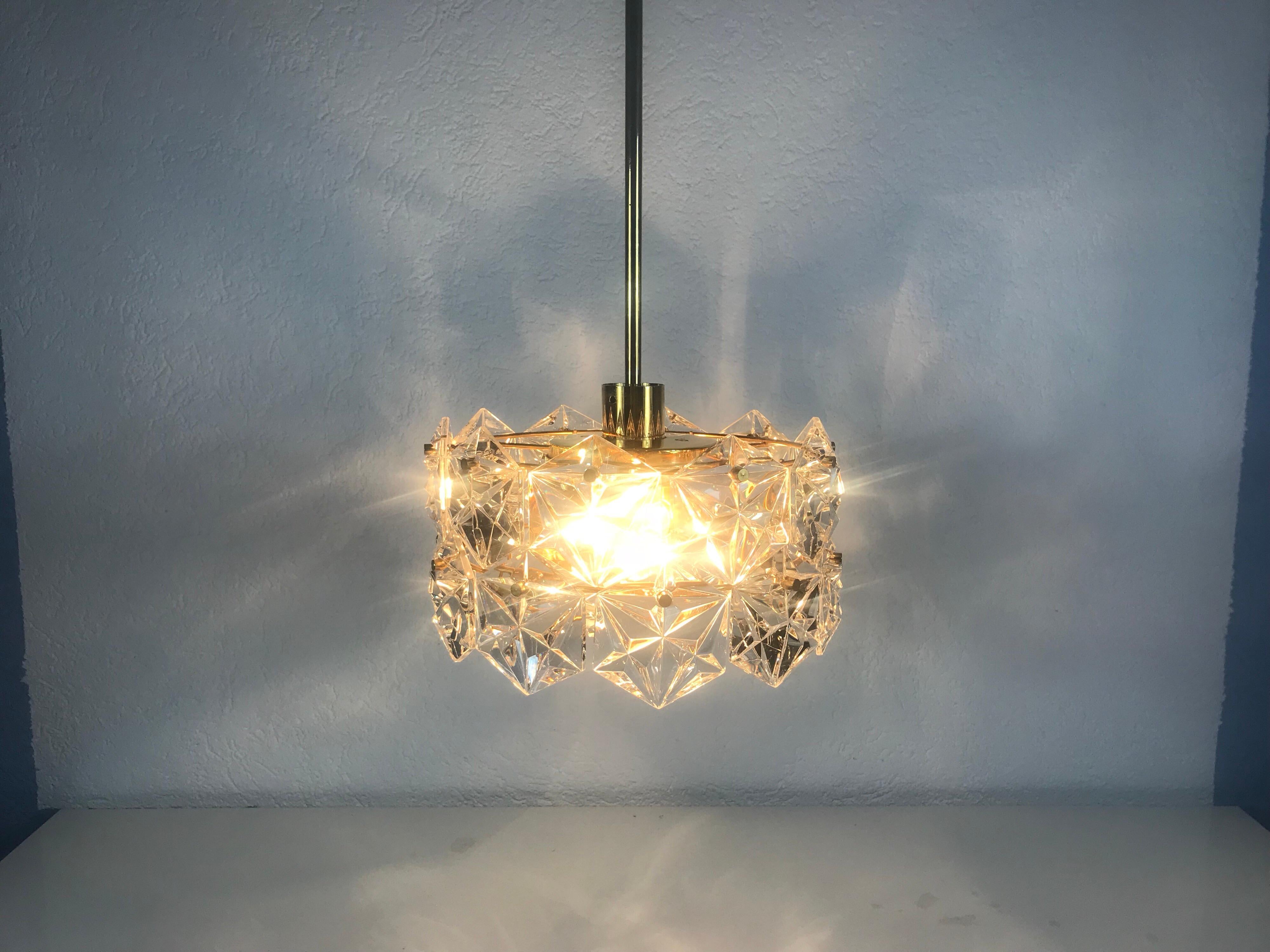 A Kinkeldey ice glass chandelier made in Germany in the 1960s. It is fascinating with its beautiful hexagonal shape of the crystal glass. All metal parts of this light are gold plated and in a very high quality standard. The crystals are all hand