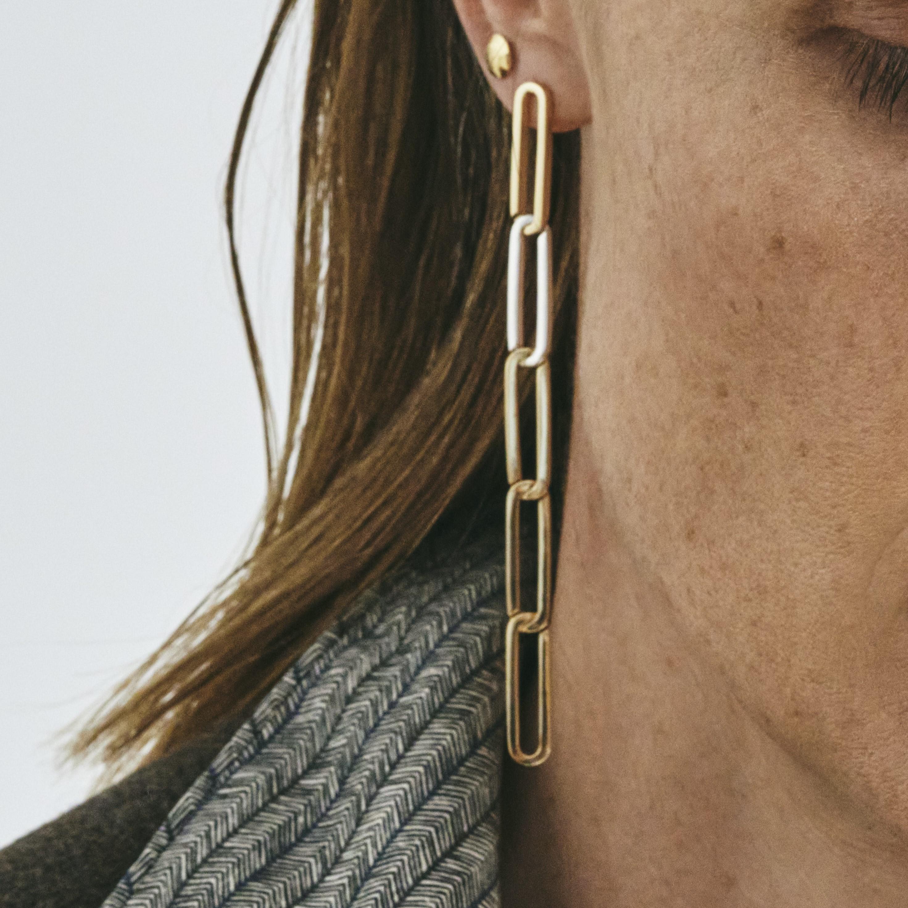 This pair of statement earrings with five sleek links is handmade in solid recycled 18k gold interposed with a single link in silver. The links are designed according to the ancient art of Japanese wood joinery – they fit neatly together when still,