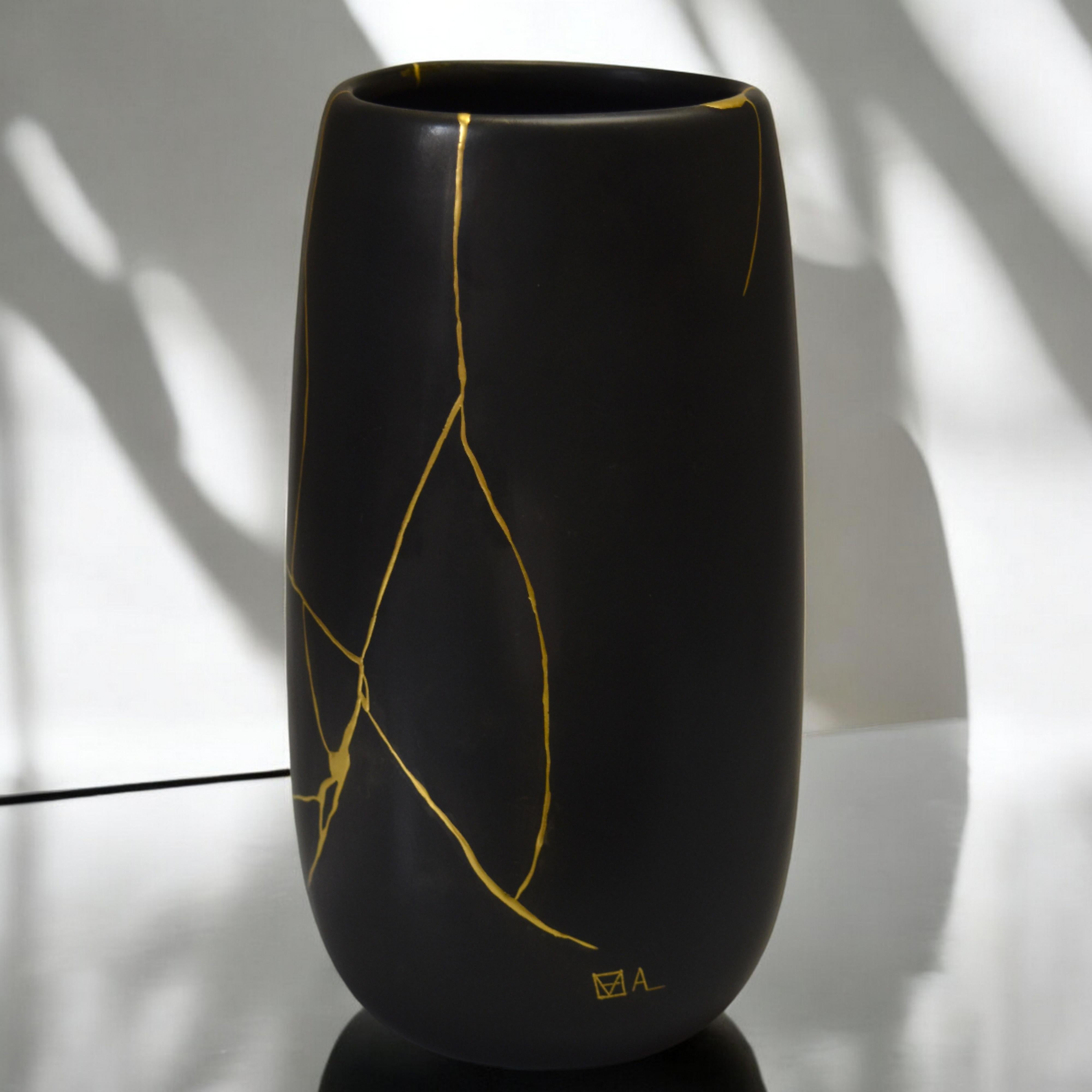 Eleganza oscura e storia luminosa: Vaso di porcellana nero opaco, cicatrici dorate

Lasciati affascinare dalla presenza enigmatica di questo vaso in porcellana nera opaca. Alto 20 cm, il suo design unico evoca la forza e la serenità delle maschere