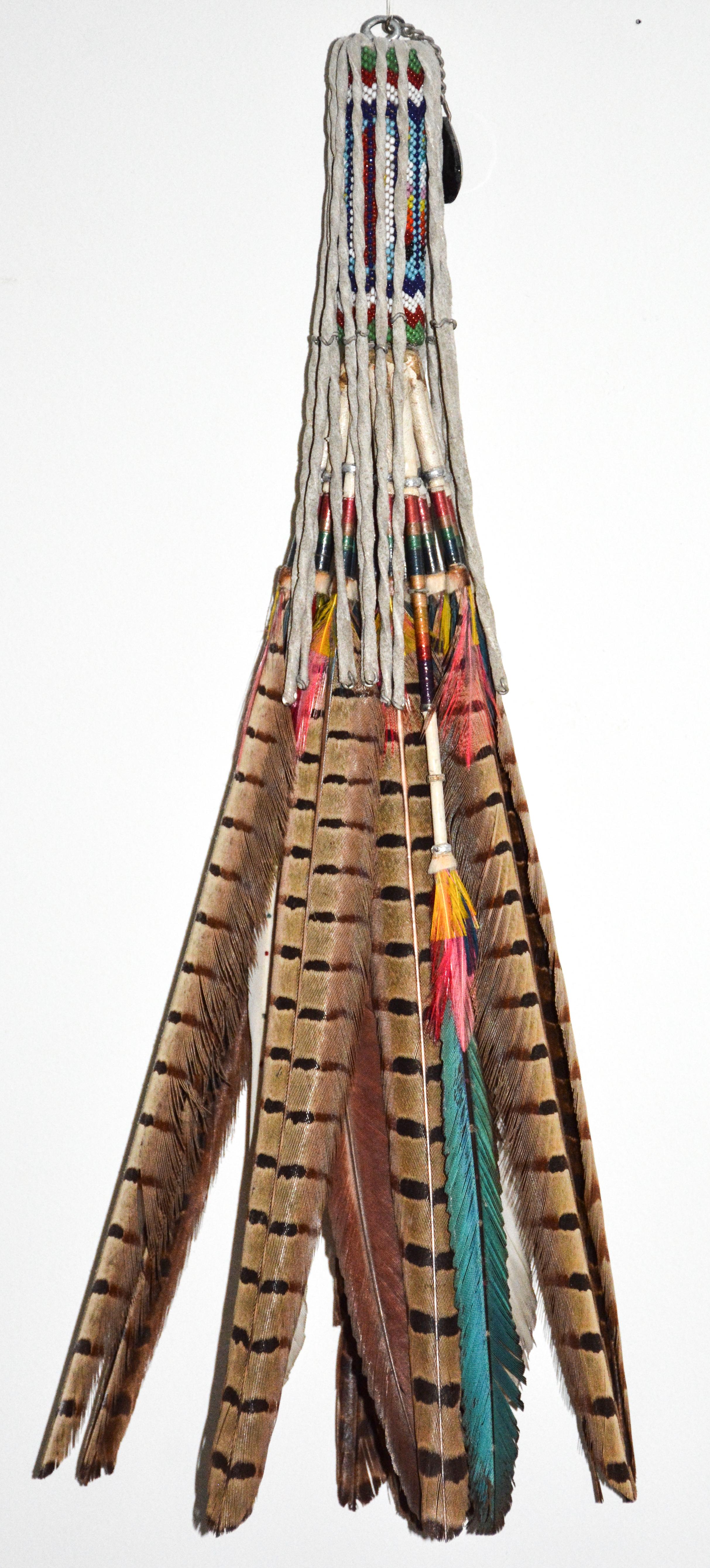 Feathered Peyote Fan, 1920

Kiowa

Glass trade beads, pheasant feathers, deerskin, dyed commercial thread, glass medallion.