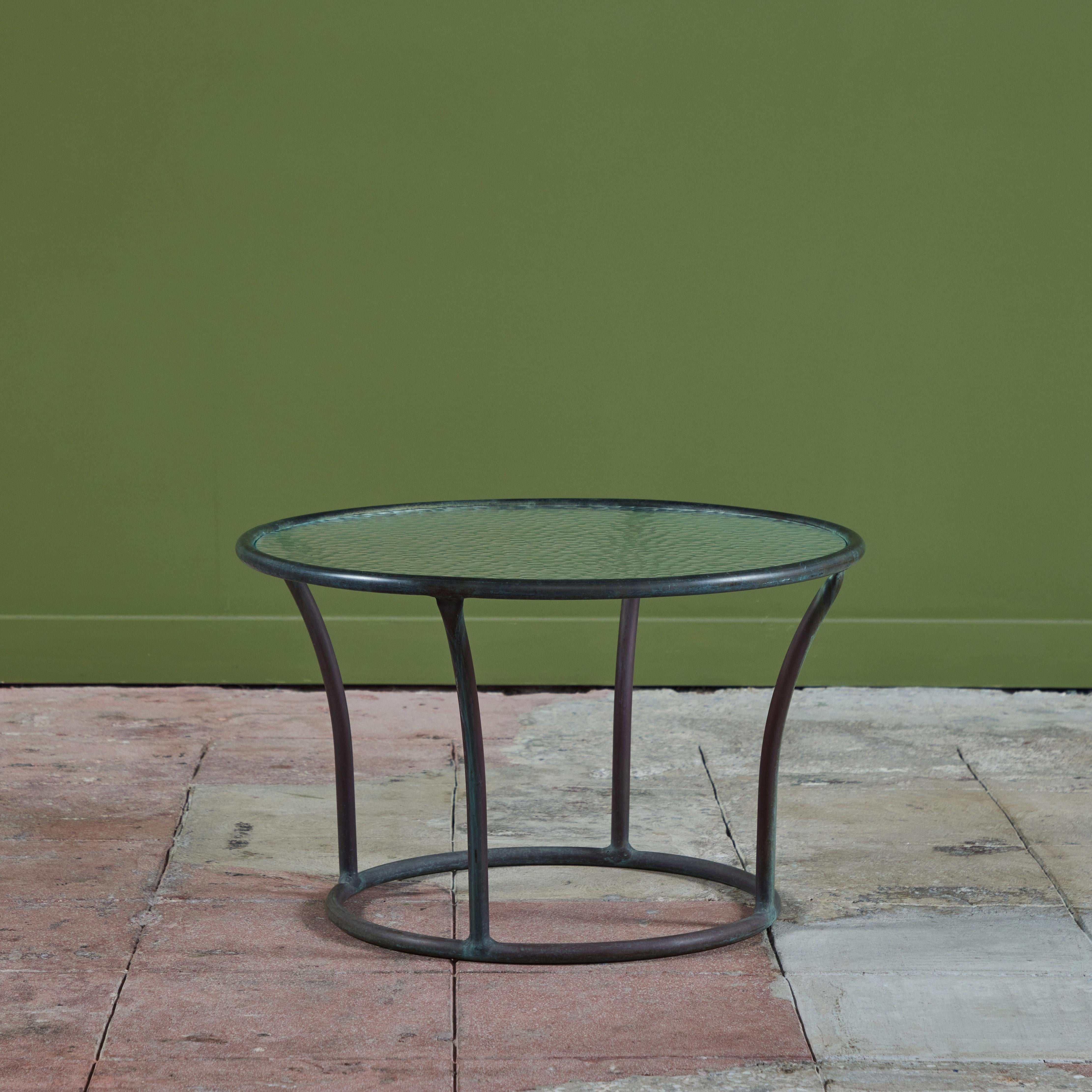 Round bronze side table with glass top by Kipp Stewart for Terra of California, USA, c.1970s. The table features four patinated bronze tubing legs which attach the round frame of the table top and base.

Dimensions
24.5