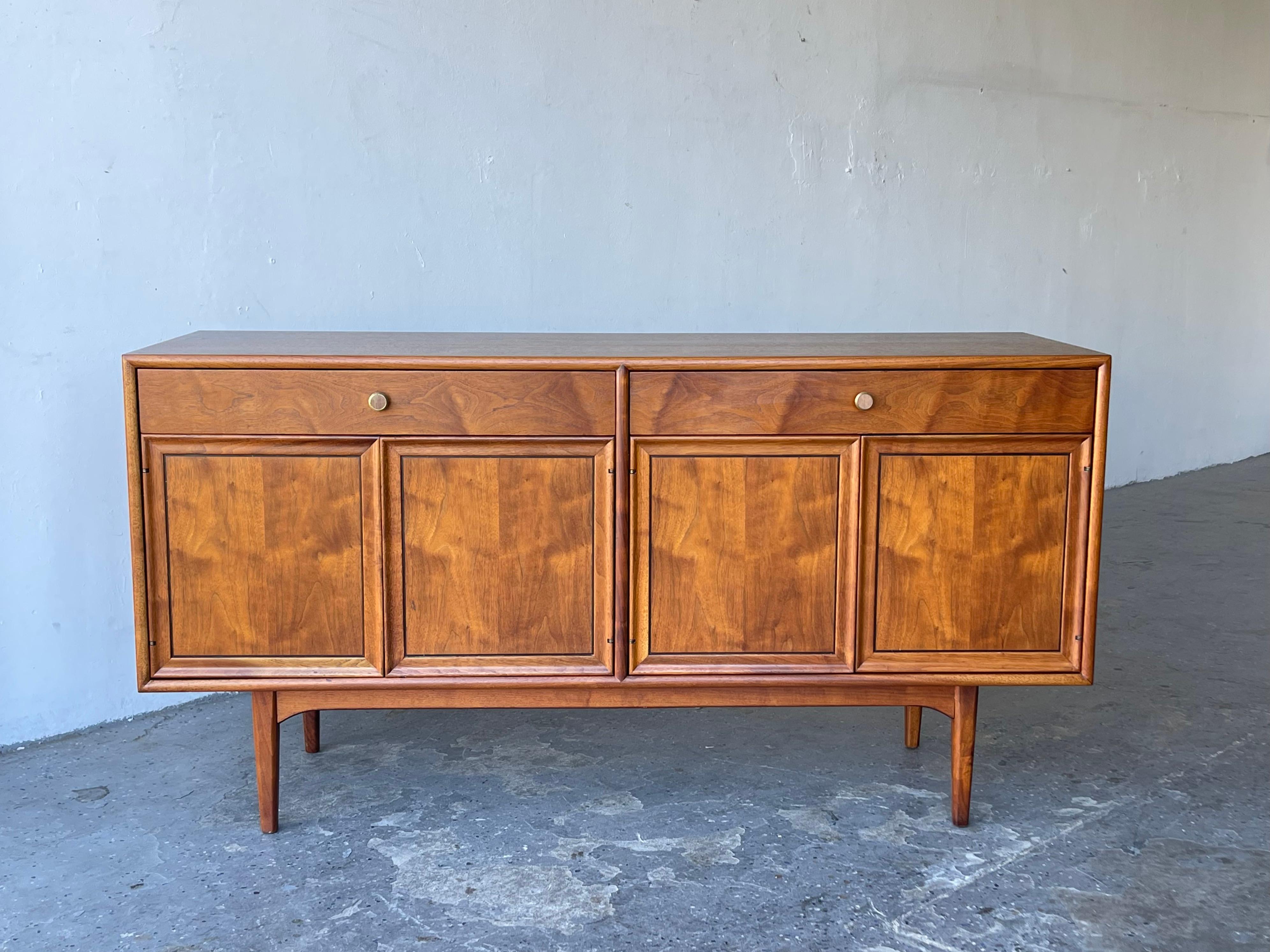 1950s walnut credenza / sideboard designed by Kipp Stewart for Drexel’s “Declaration” line. Composed of two sets of hinged doors which open to reveal a single, removable shelf per side. 


 The left side additionally features two horizontal