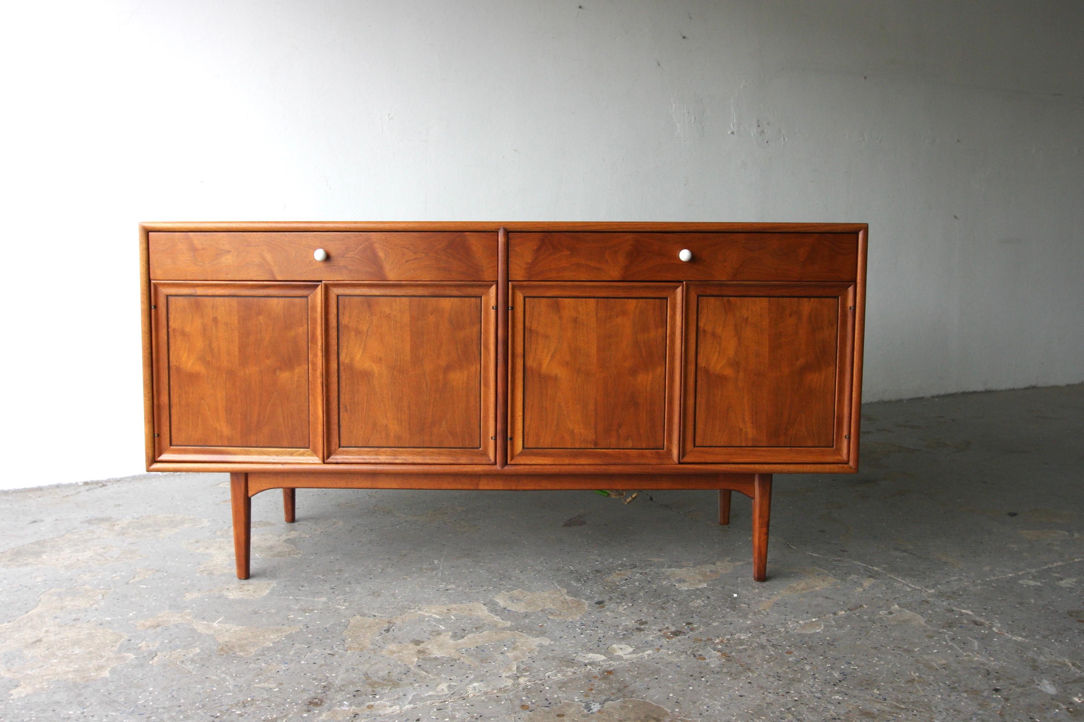 
1950s walnut credenza / sideboard designed by Kipp Stewart for Drexel’s “Declaration” line. Composed of two sets of hinged doors which open to reveal a single, removable shelf per side. 


 The left side additionally features two horizontal storage