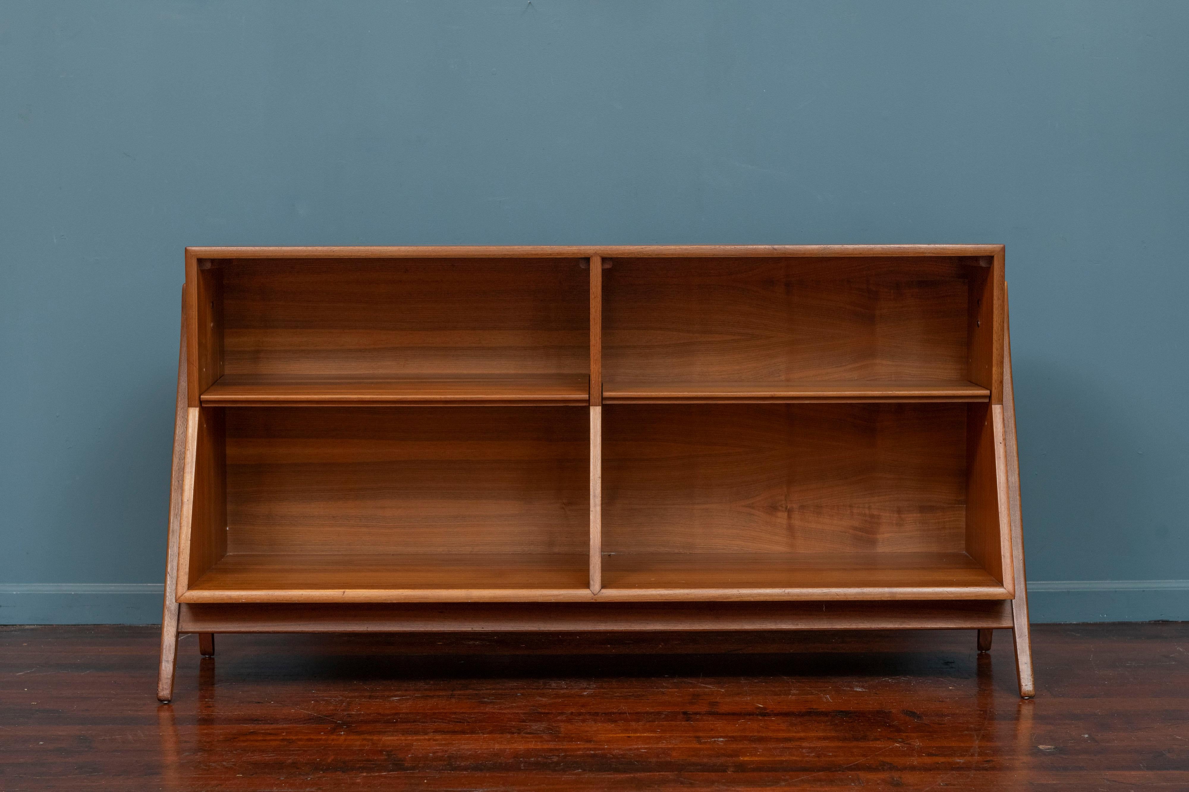 Kipp Stewart design bookcase or console table for his Declaration Line for Drexel Furniture. Made in figured walnut with two adjustable shelves perfect for records or displaying your collectibles. Striking profile with splayed legs and angular