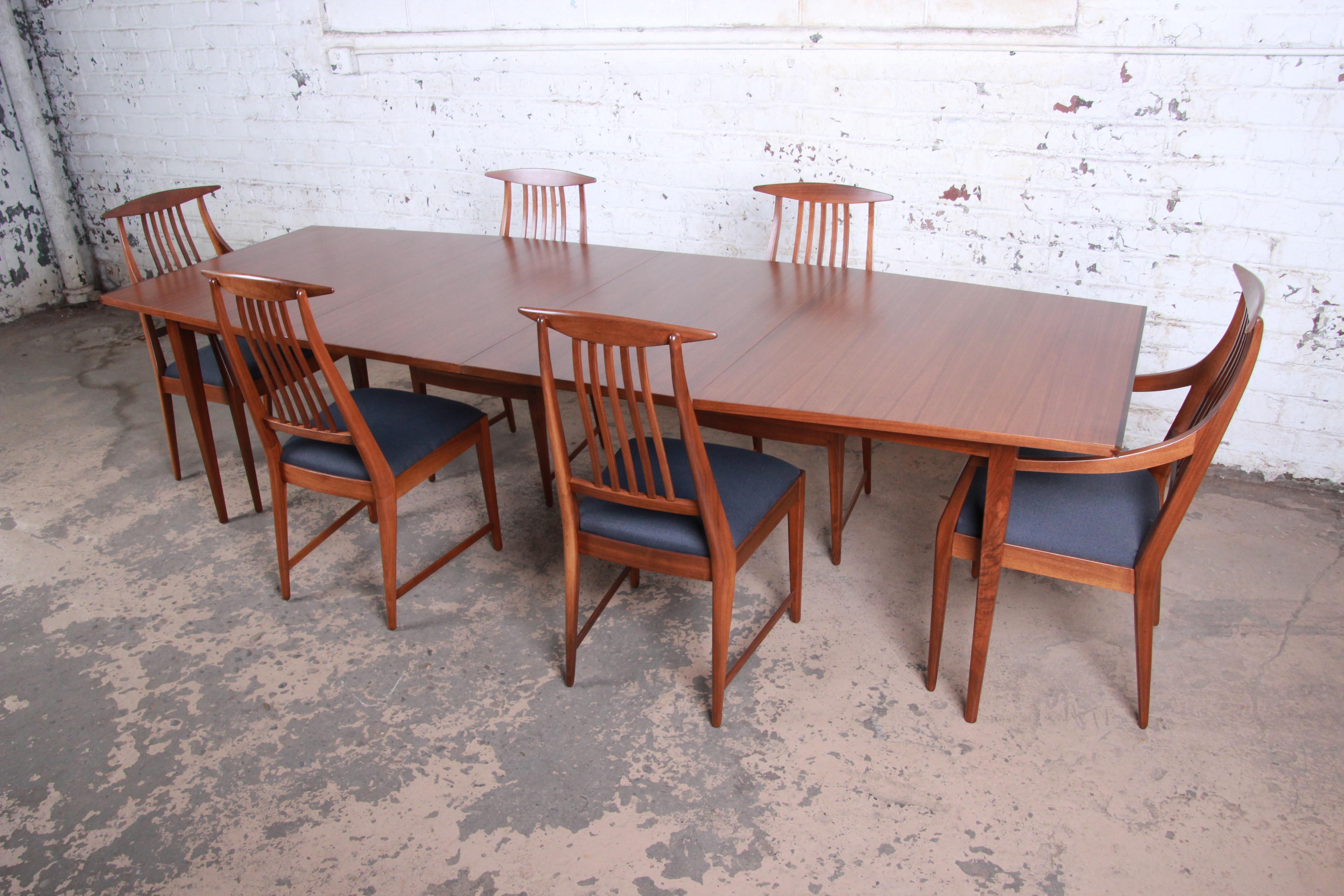 A rare and exceptional Mid-Century Modern dining set designed by Kipp Stewart for his American Design Foundation line for Calvin Furniture. The set includes the extension dining table with two leaves and six chairs. The table features stunning