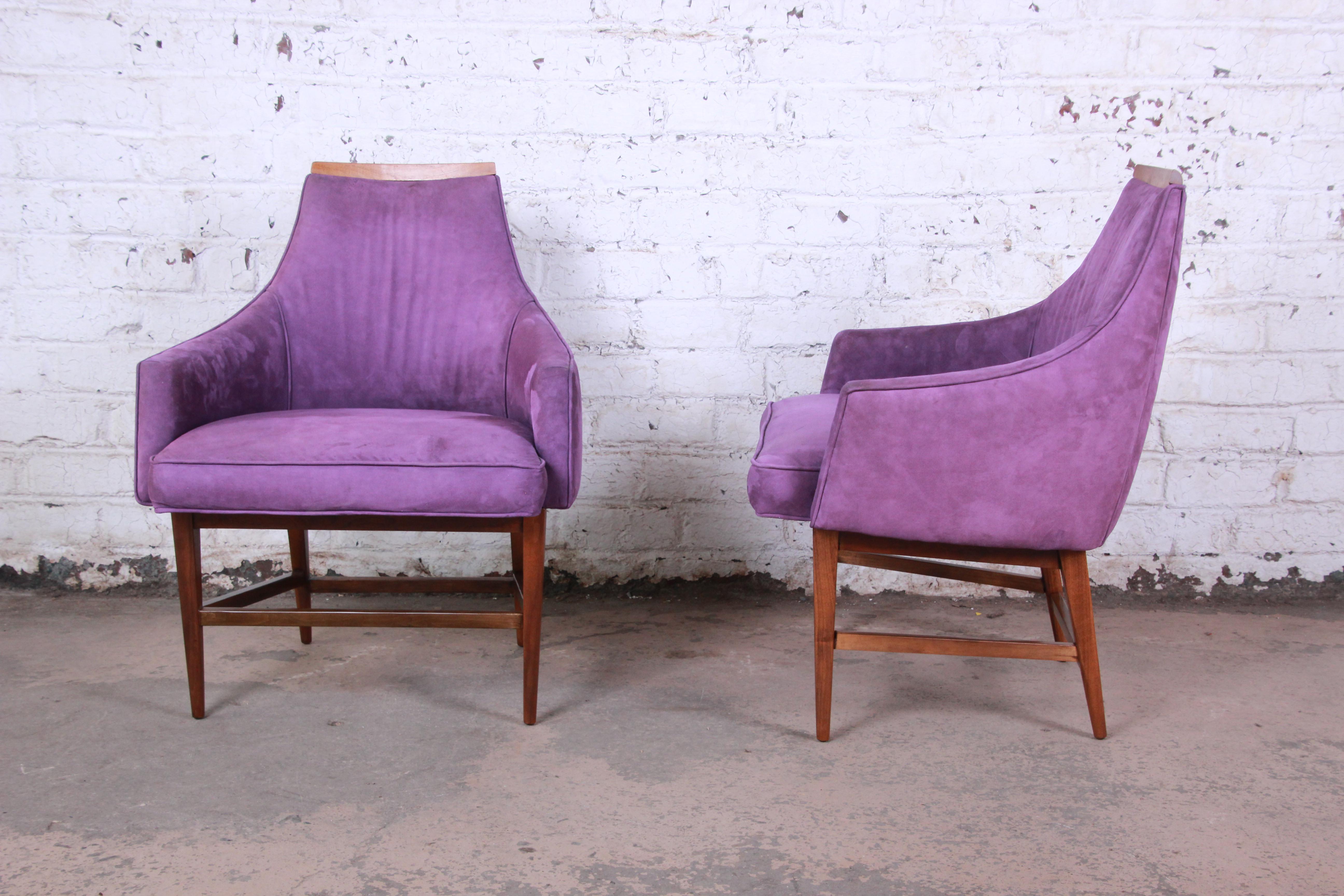 A gorgeous pair of Mid-Century Modern lounge chairs designed by Kipp Stewart for Directional. The chairs feature solid walnut frames, striking original purple upholstery, and sleek midcentury design. A perfect blend of style and comfort. The walnut