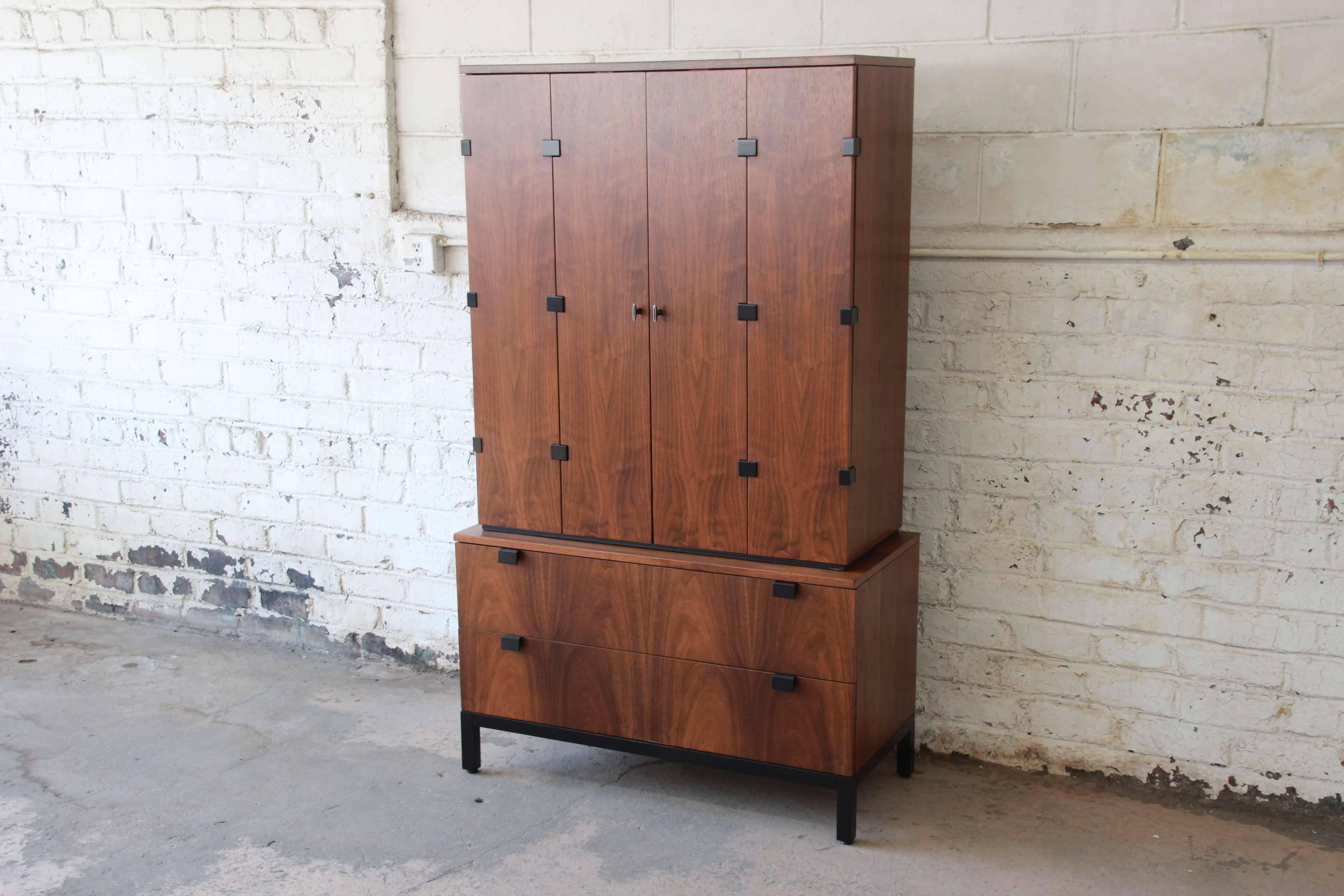 An outstanding Mid-Century Modern walnut gentleman's chest designed by Milo Baughman for Directional. The two-piece cabinet features stunning walnut wood grain and sleek midcentury design. It offers ample room for storage. The top piece has numerous