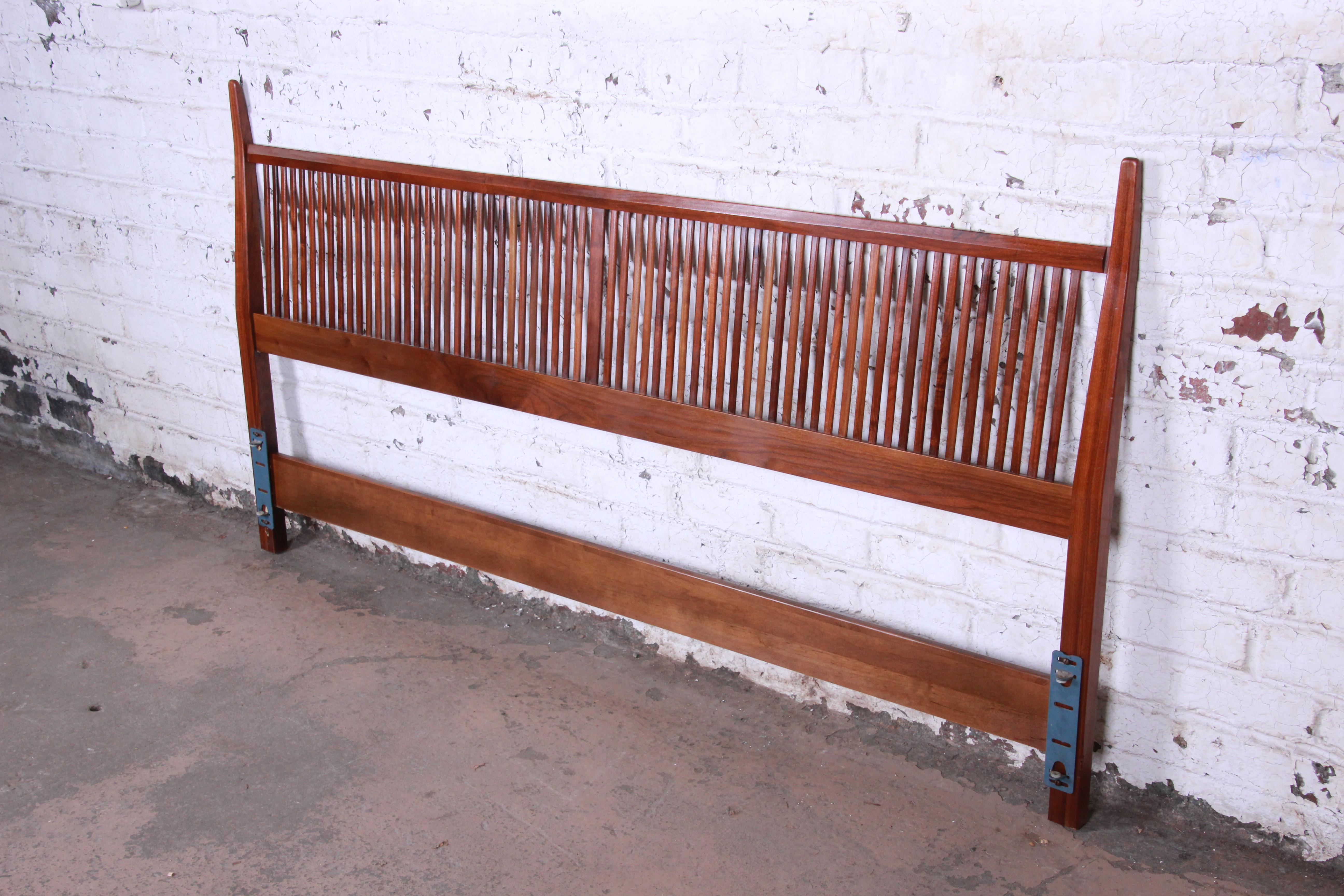 An exceptional Mid-Century Modern sculpted walnut king size headboard. The headboard was designed by Kipp Stewart for his American design foundation line for directional and produced by Calvin Furniture. It features solid walnut construction with