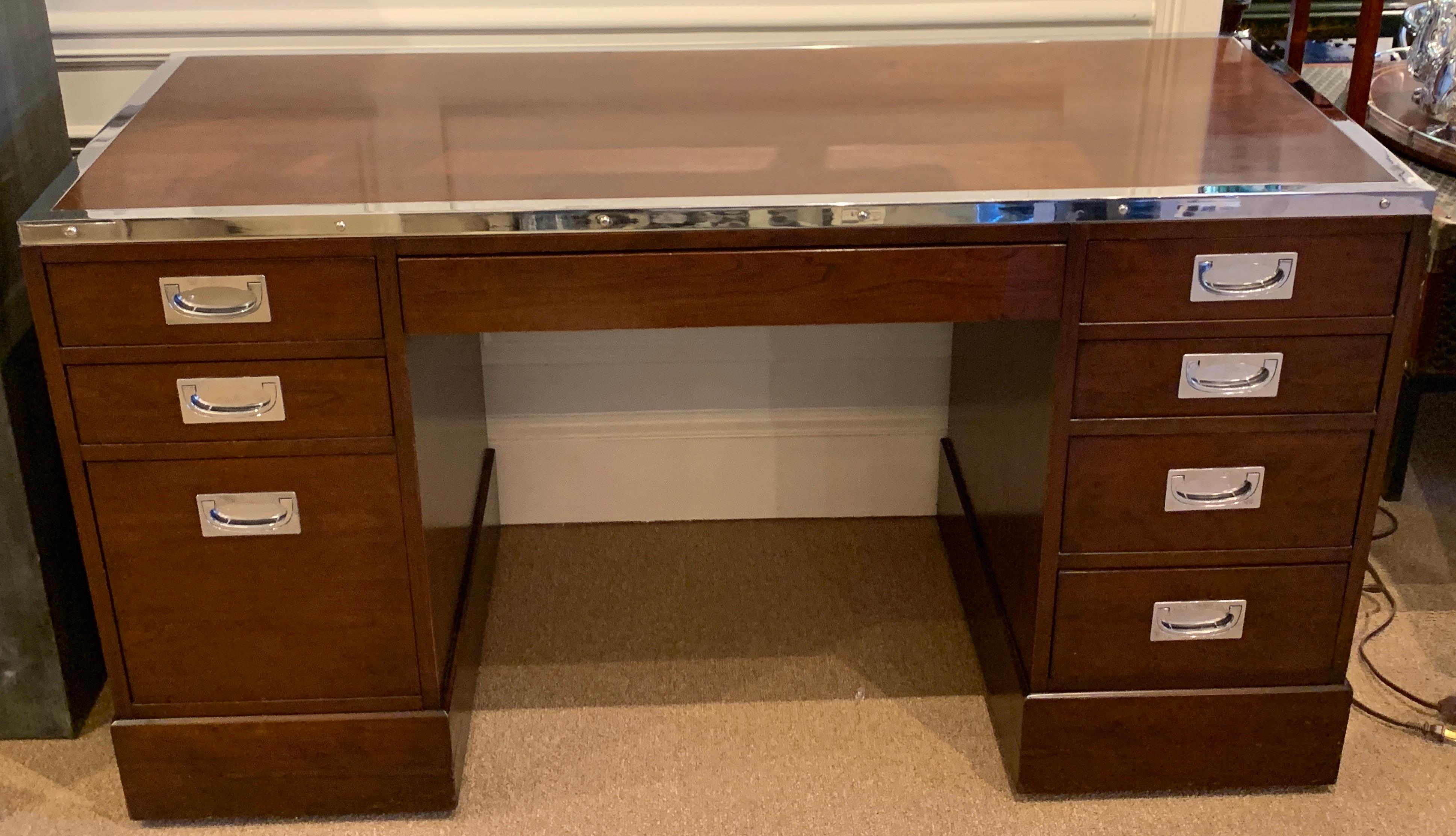 Kipp Stewart for Directional special order Campaign desk, 6400-B, with silver plated brass (Standard order are brass mounts, not silvered) mounts on a mahogany case fitted with 8-drawers including a concealed middle drawer and file drawer to the
