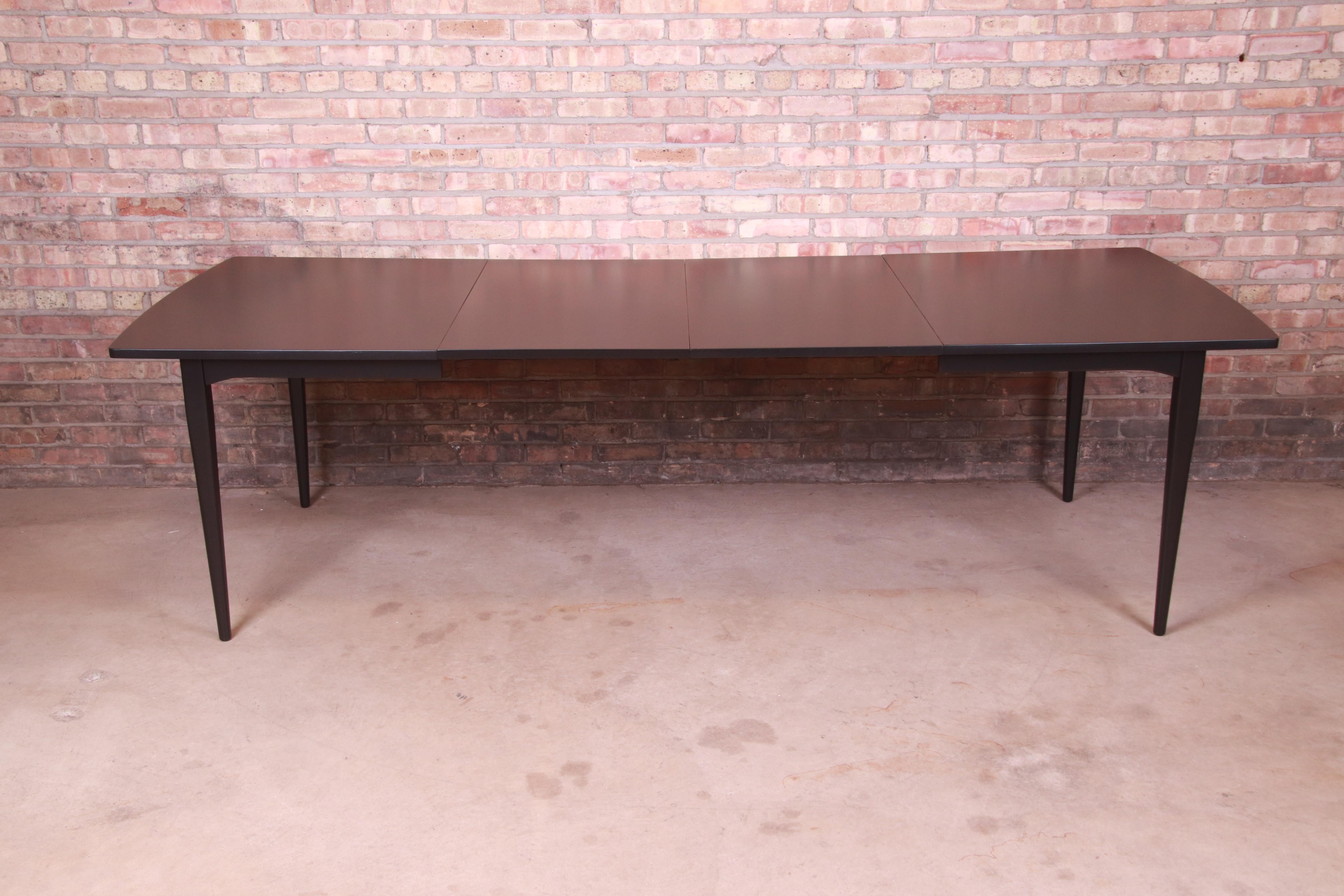 A gorgeous mid-century modern black lacquered walnut extension dining table

By Kipp Stewart for Drexel, 