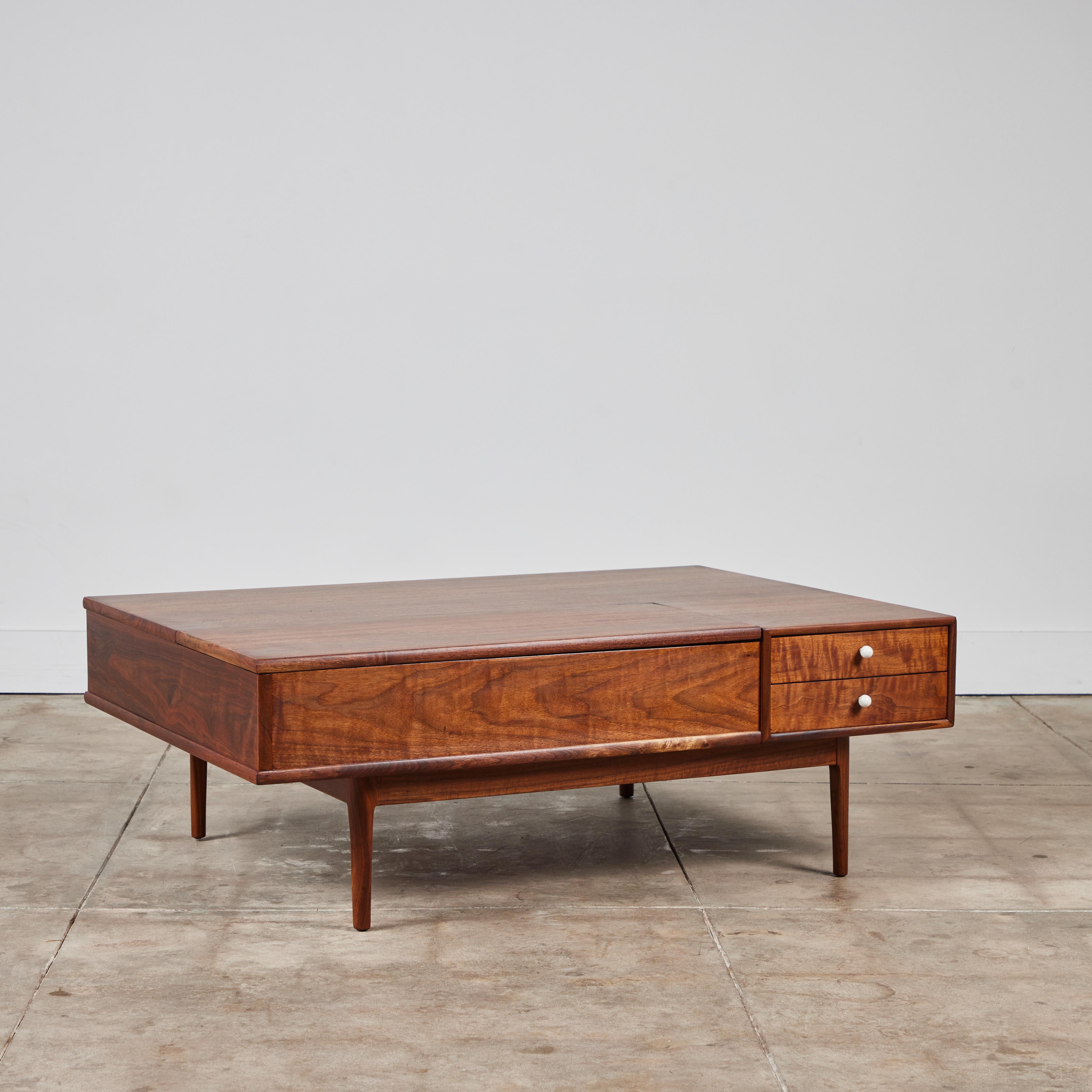 From the iconic Drexel Declaration collection by Kipp Stewart and Stewart MacDougall, this is a deep, rectangular table in walnut wood on recessed legs. Two drawers with signature porcelain drawer pulls sit in the right front corner, and a panel