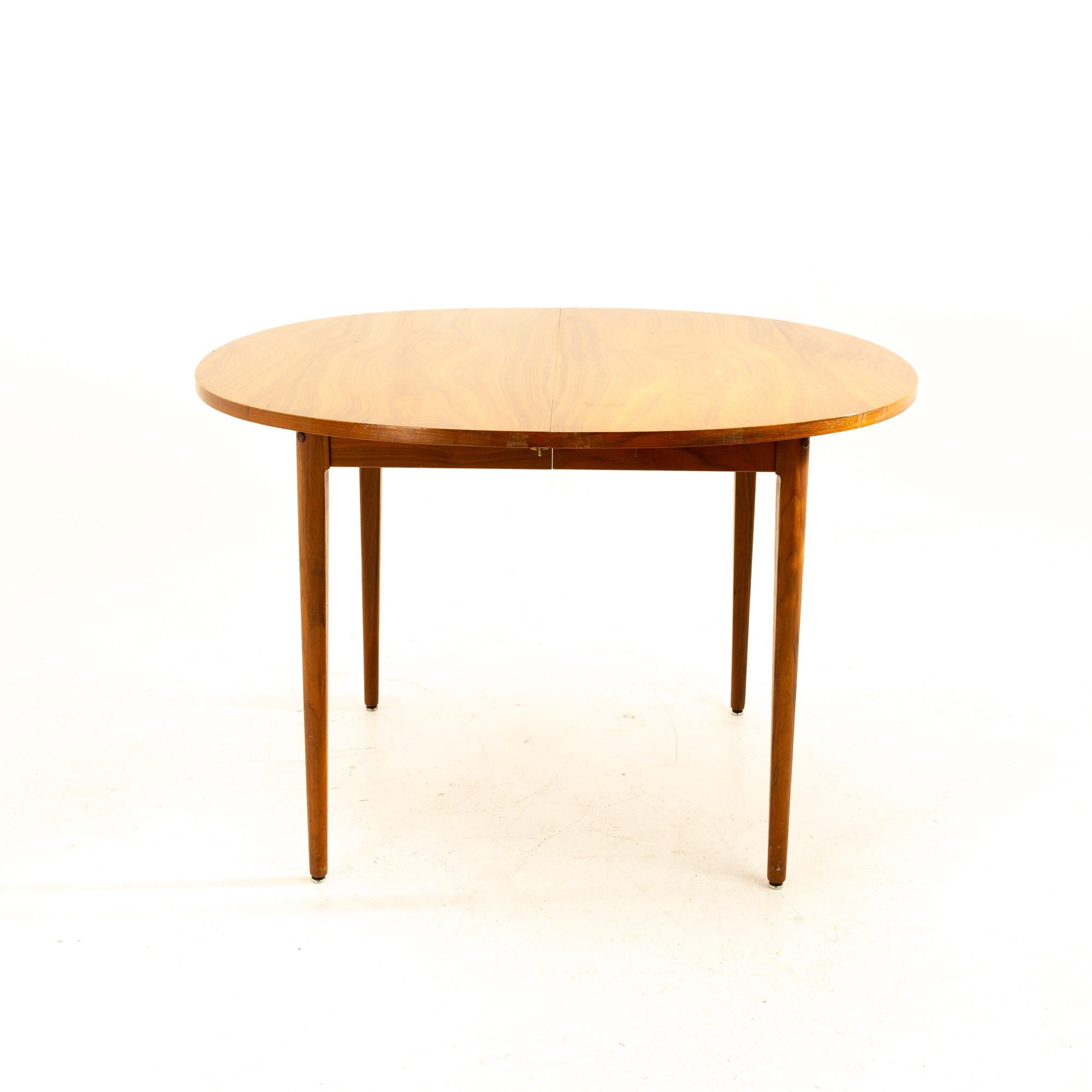 Kipp Stewart for Drexel Declaration mid century expanding round walnut dining table with 2 leaves

Table measures: 44.25 wide x 44.25 deep x 29.25 high, with a chair clearance of 26.5 inches, each leaf is 22 inches wide, making a maximum table width