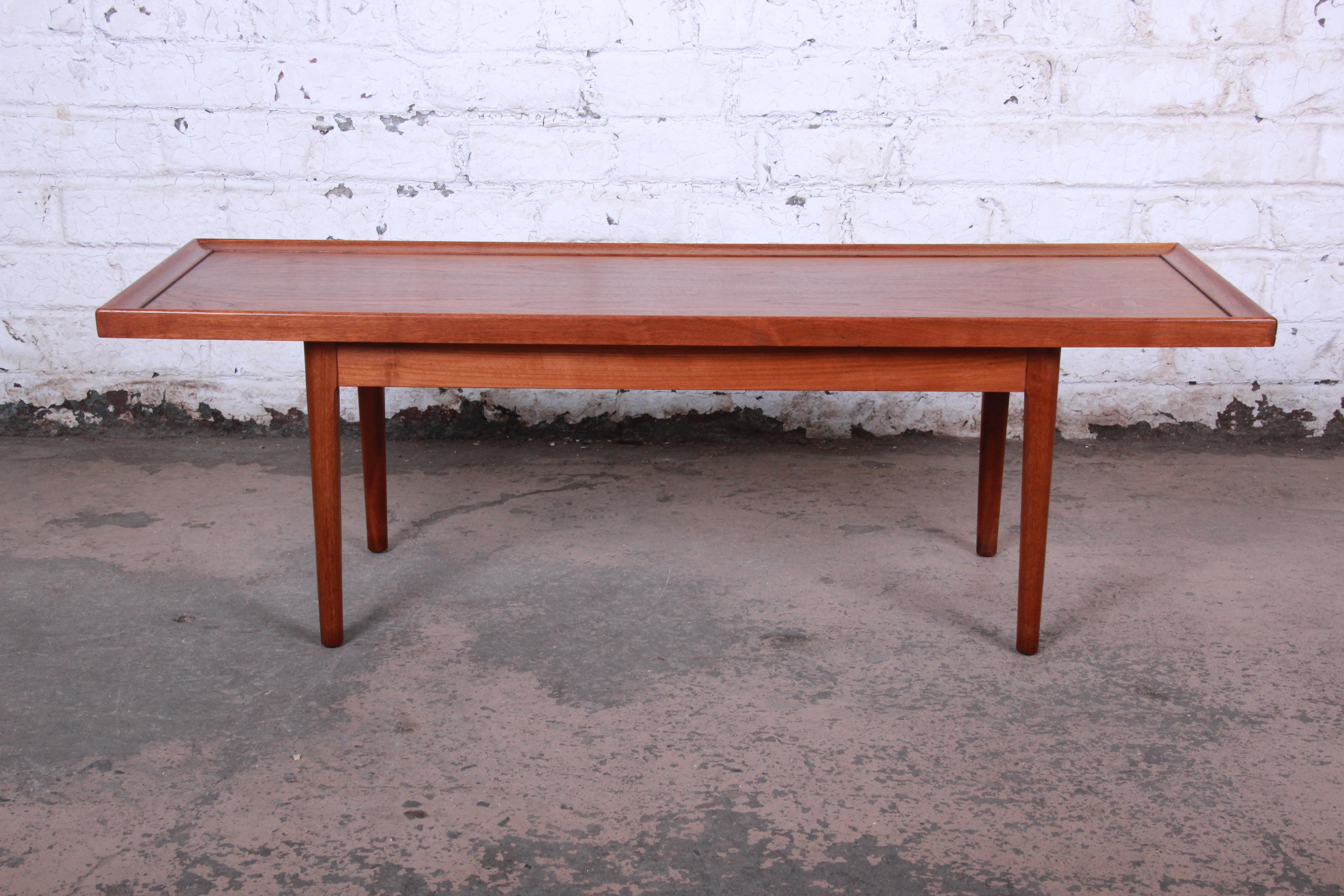 Offering a gorgeous Mid-Century Modern walnut coffee table designed by Kipp Stewart for his Declaration line for Drexel. The table features beautiful walnut wood grain and sleek Danish-inspired design.