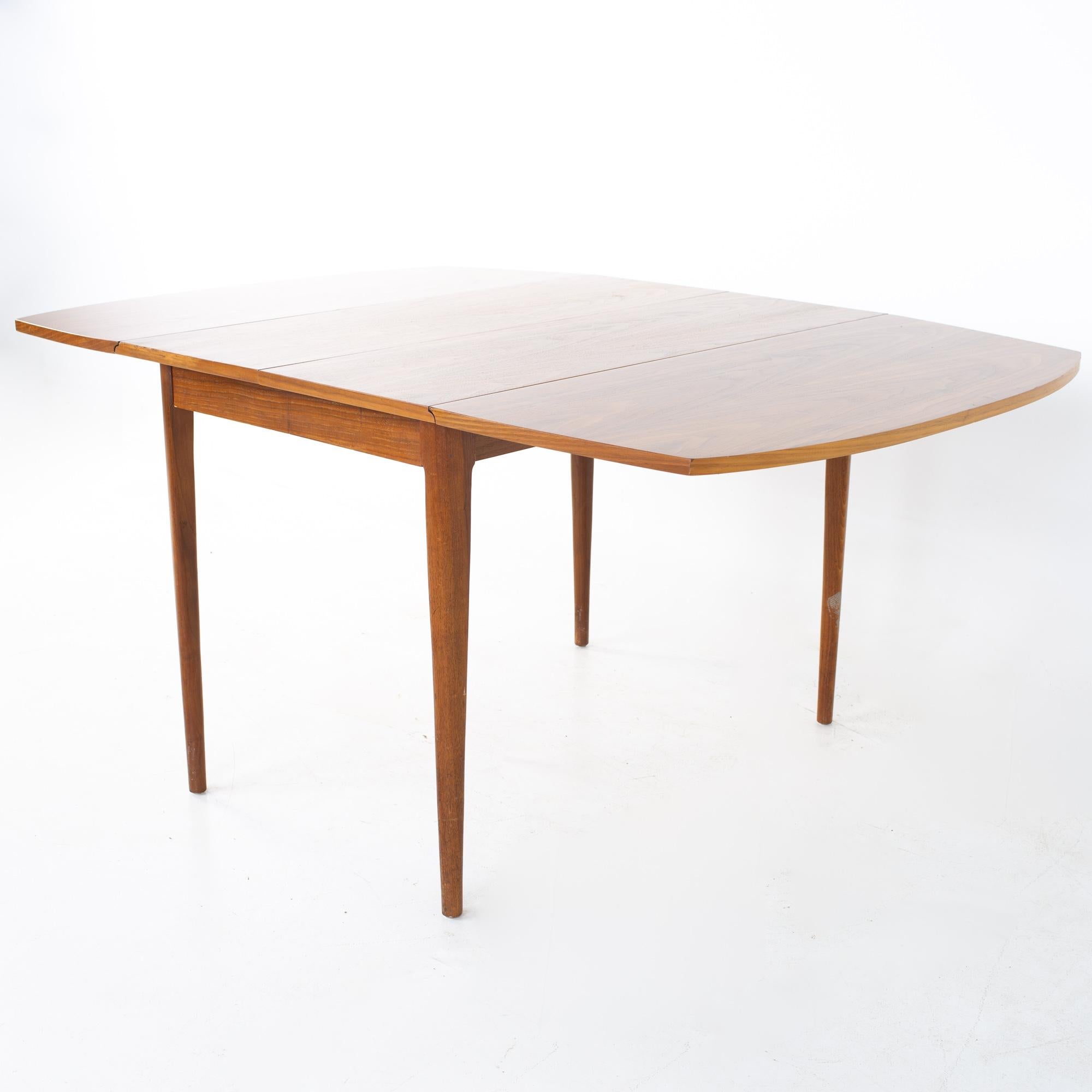 Kipp Stewart for Drexel Declaration Mid Century walnut drop leaf dining table
Table measures: 27 wide x 42 deep x 29 inches high; each leaf is 18 inches wide, making a maximum table width of 63 inches when both leaves are used. This table has a
