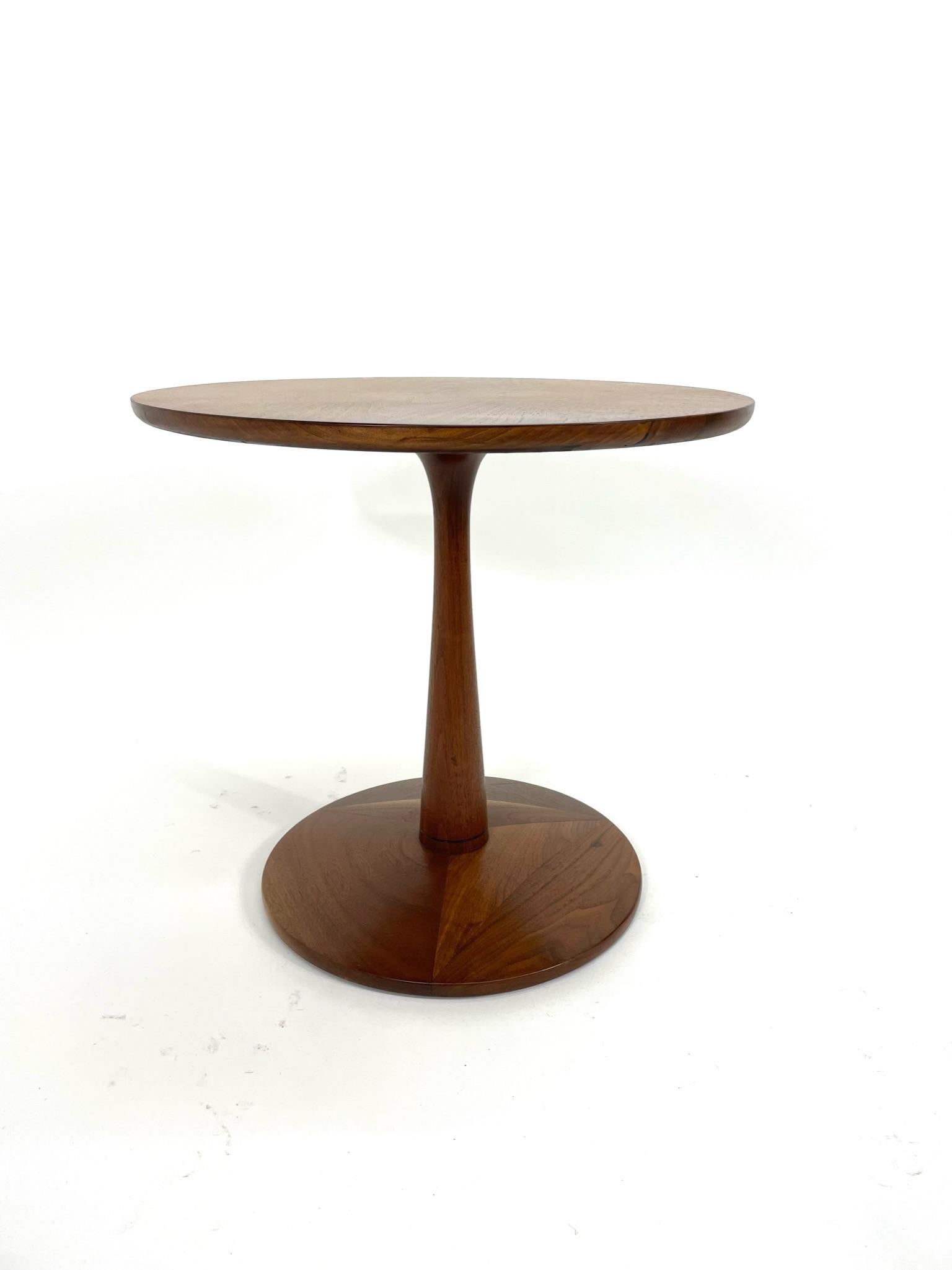 Kipp Stewart for Drexel side table from the Declaration line features book-matched walnut veneer on the top and a pedestal base. It has been restored to excellent condition to show off the beautiful grain on both the top and base. It's clean lines