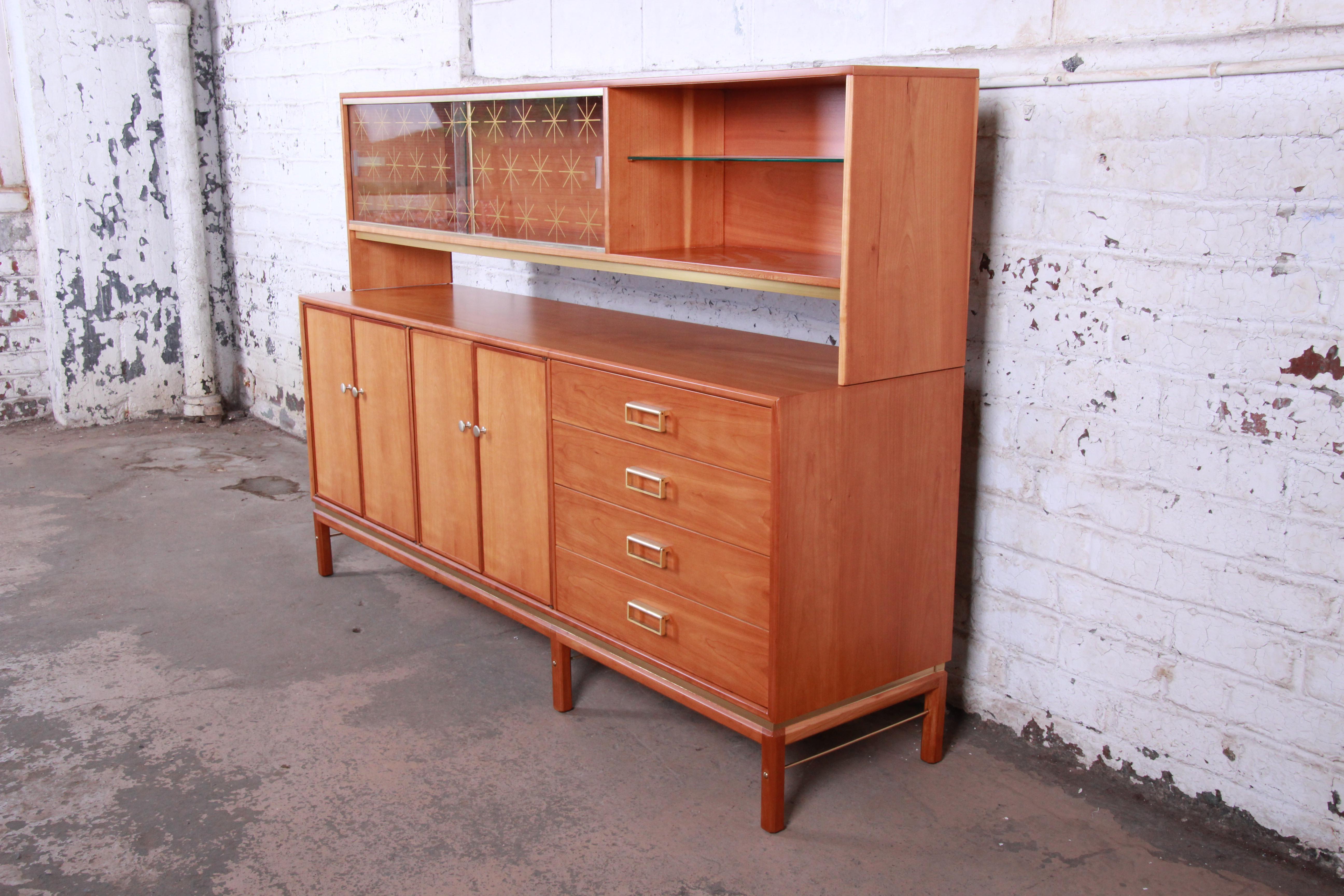 An exceptional Mid-Century Modern sideboard with hutch top designed by Kipp Stewart for his Sun Coast line for Drexel Furniture. The sideboard features stunning cherrywood grain and sleek midcentury design. It offers ample storage, with four