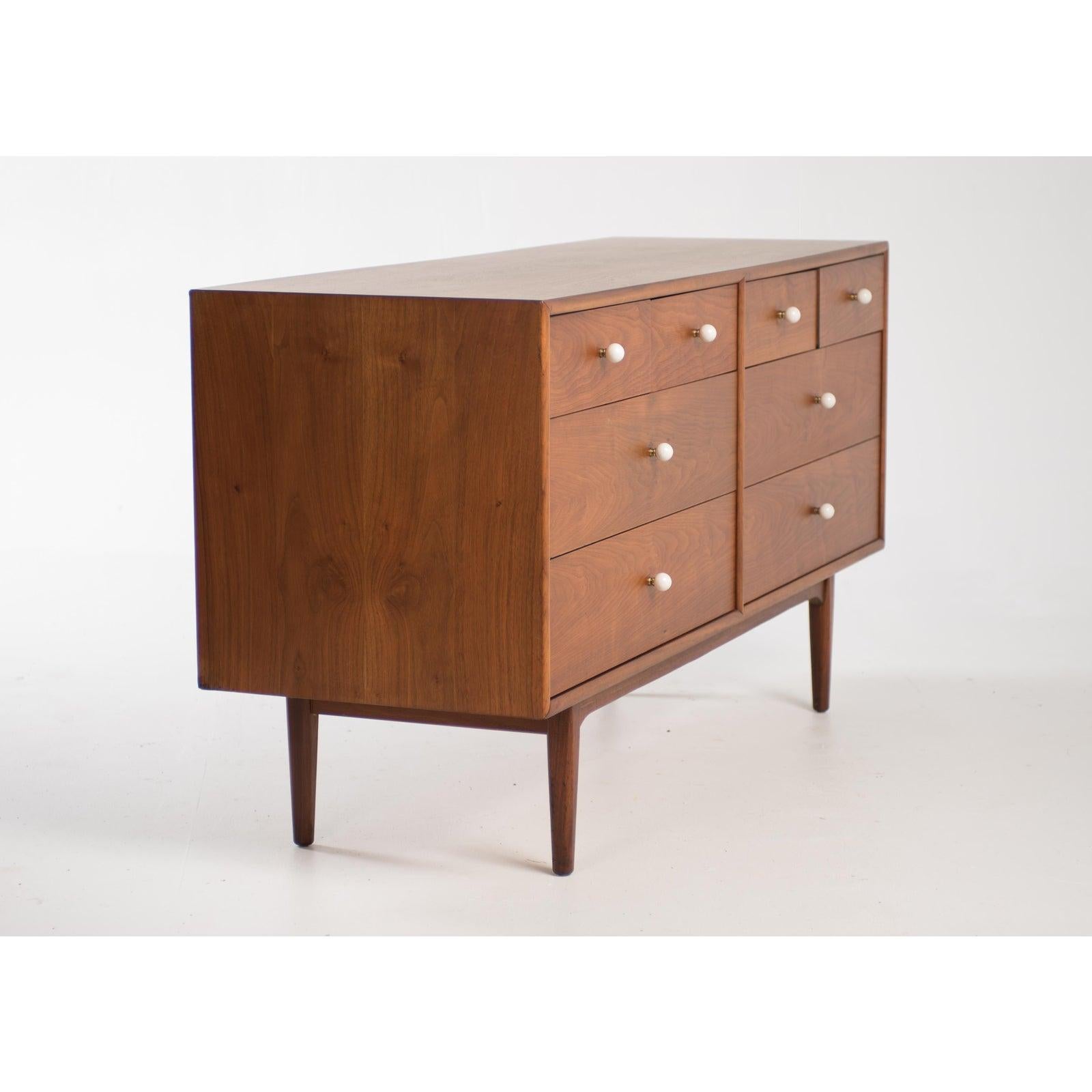 1960s Mid-Century Modern eight drawer dresser or credenza designed by Kipp Stewart and Stewart MacDougall for Drexel’s declaration collection. Walnut frame with white porcelain ball knobs on a brass fitting, clearly influenced by George Nelson's