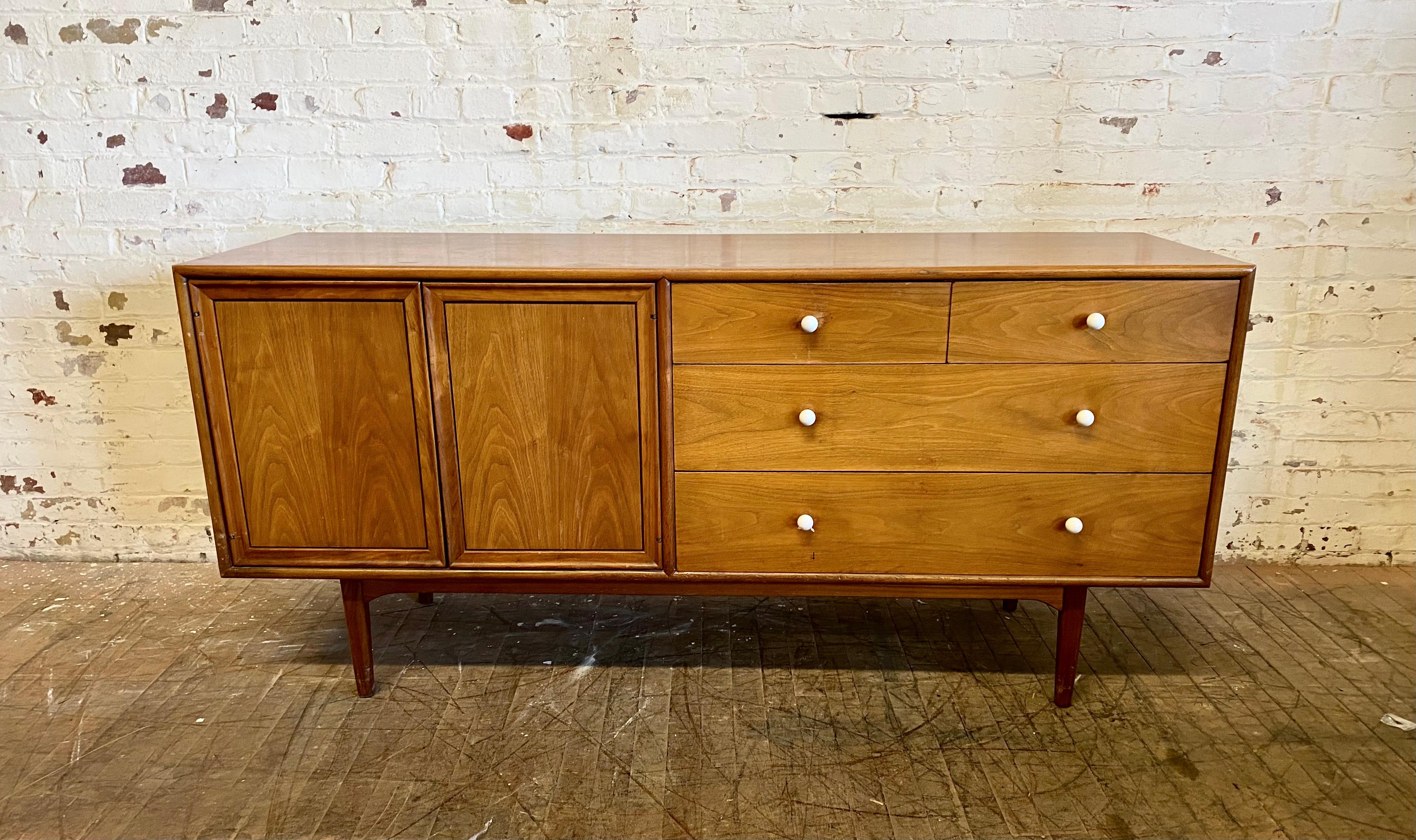 Ten-drawer dresser by Kip Stewart and Stewart MacDougall for their Drexel Declaration collection. Four exposed drawers with original spherical porcelain knobs and brass spacers. Six more drawers are revealed when pair of doors open, minor blemishes