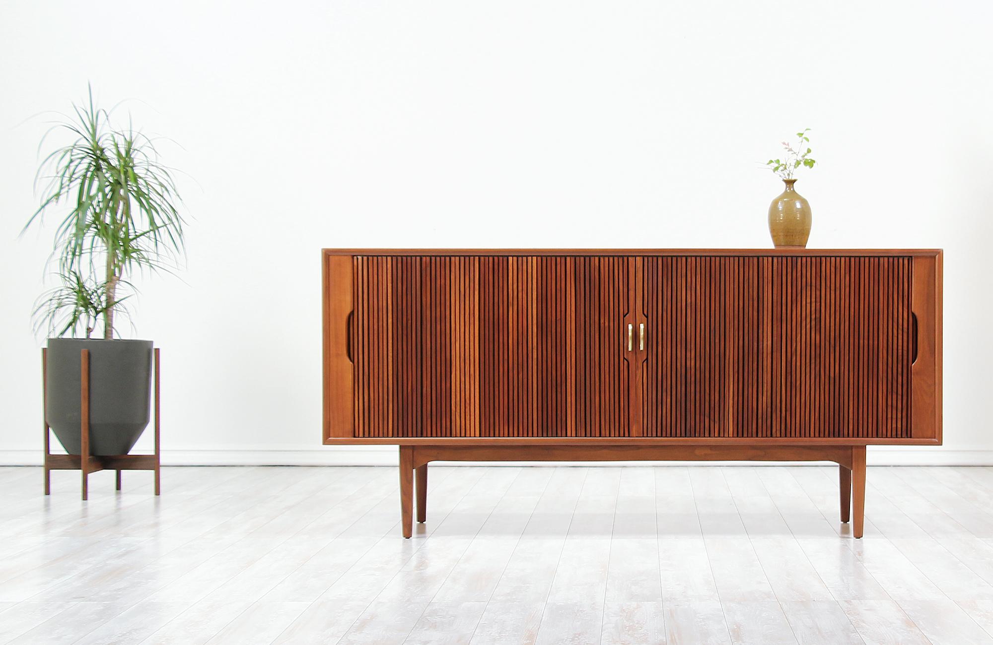 Mid-Century Modern tambour door credenza designed by Kipp Stewart & Stewart MacDougall for Drexel’s “Declaration” line in the United States, circa 1950s. This Fine credenza features a walnut wood frame with a beautiful grain detail and smooth