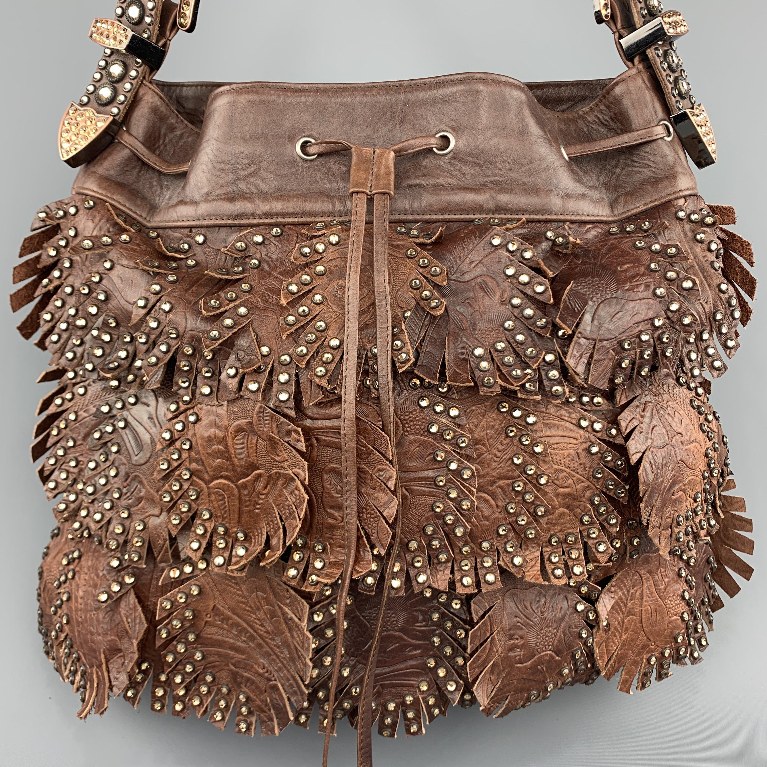KIPPYS handbag comes in brown leather covered in embossed fringed leaf fringe with rhinestone appliques, top zip closure, and western cowgirl buckle shoulder strap.
 
Excellent Pre-Owned Condition.
 
Measurements:
 
Length: 13 in.
Width: 2
