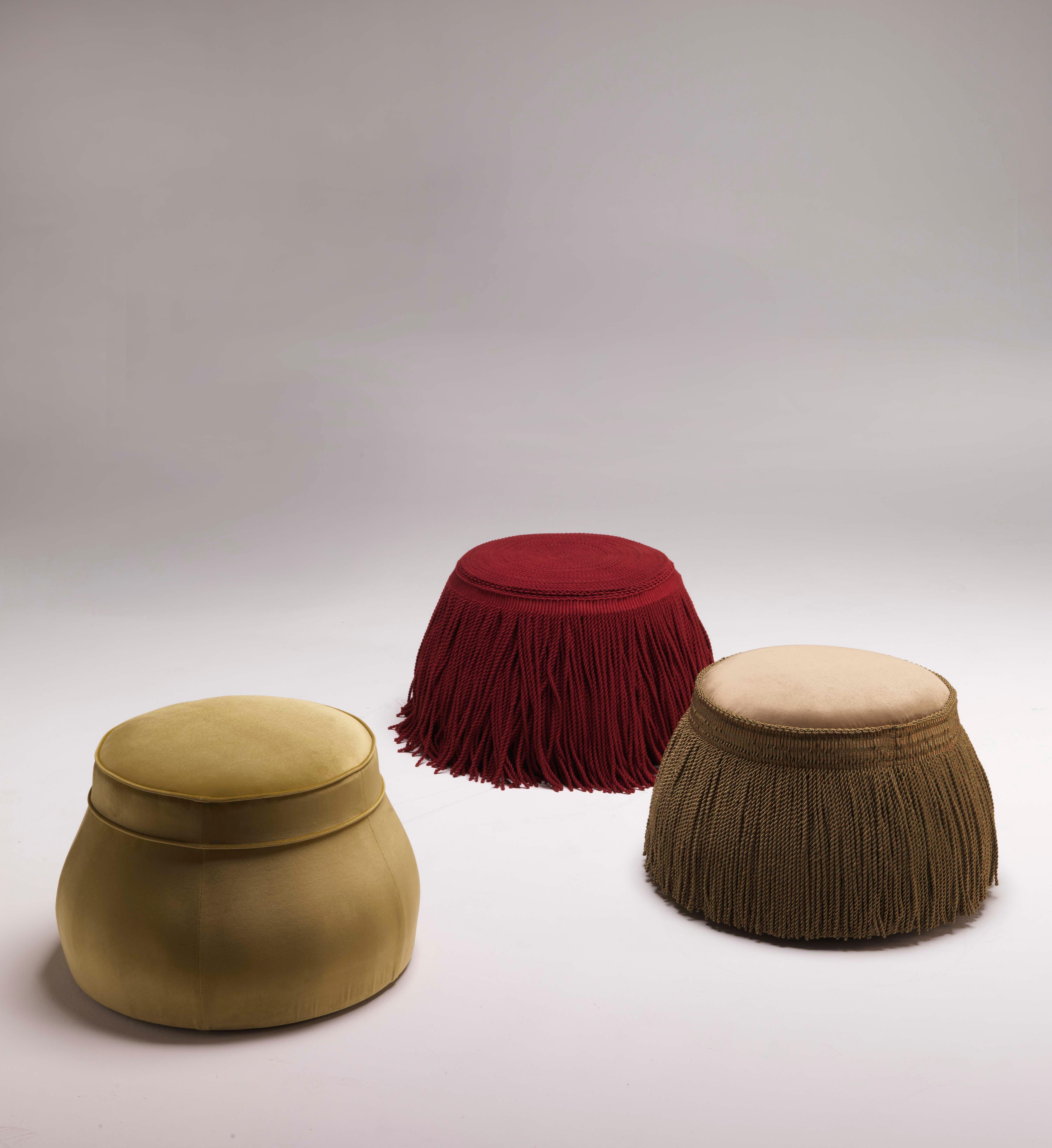 Elevate your space with the Kir Royal Footstool, a delightful creation by designer Christophe de la Fontaine. This footstool showcases an intriguing blend of irony and opulence, characterized by its lavish trimming and fringe. With a wooden
