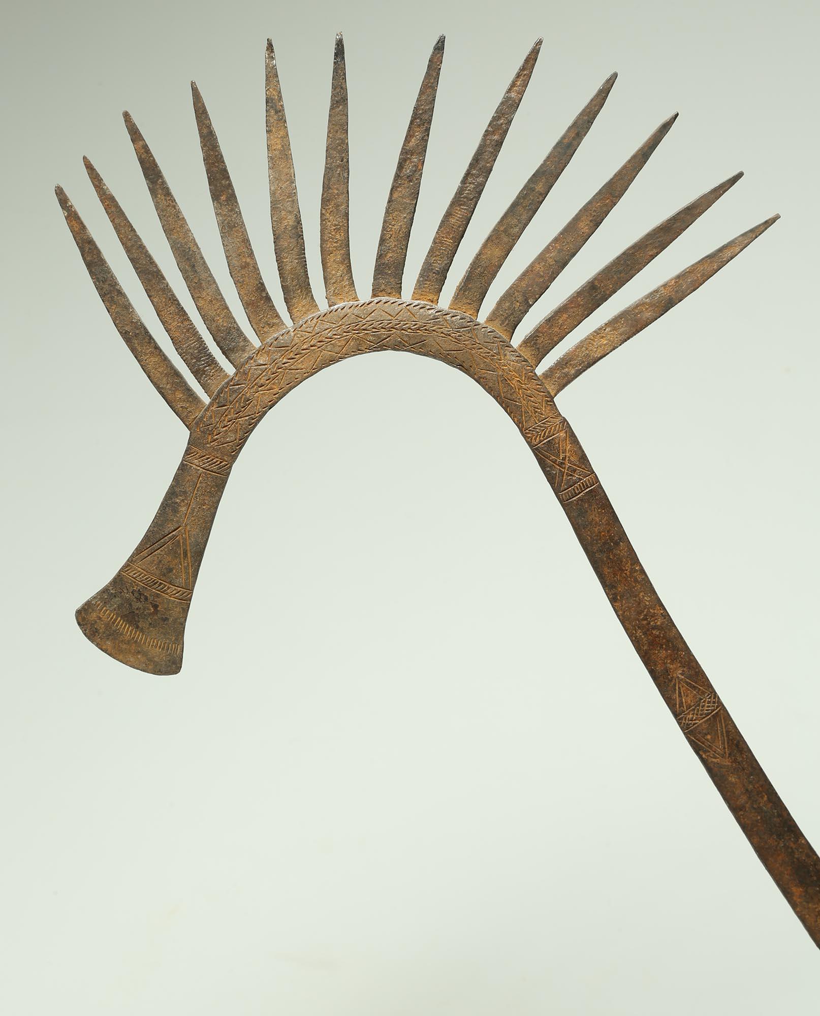 Forged iron currency object or staff in the form of a stylized fancy crested bird, from the Kirdi people, Nigeria. Added decoration on the surface in the form of fine incised lines. Created early 20th century, on custom metal base. Measures:  23