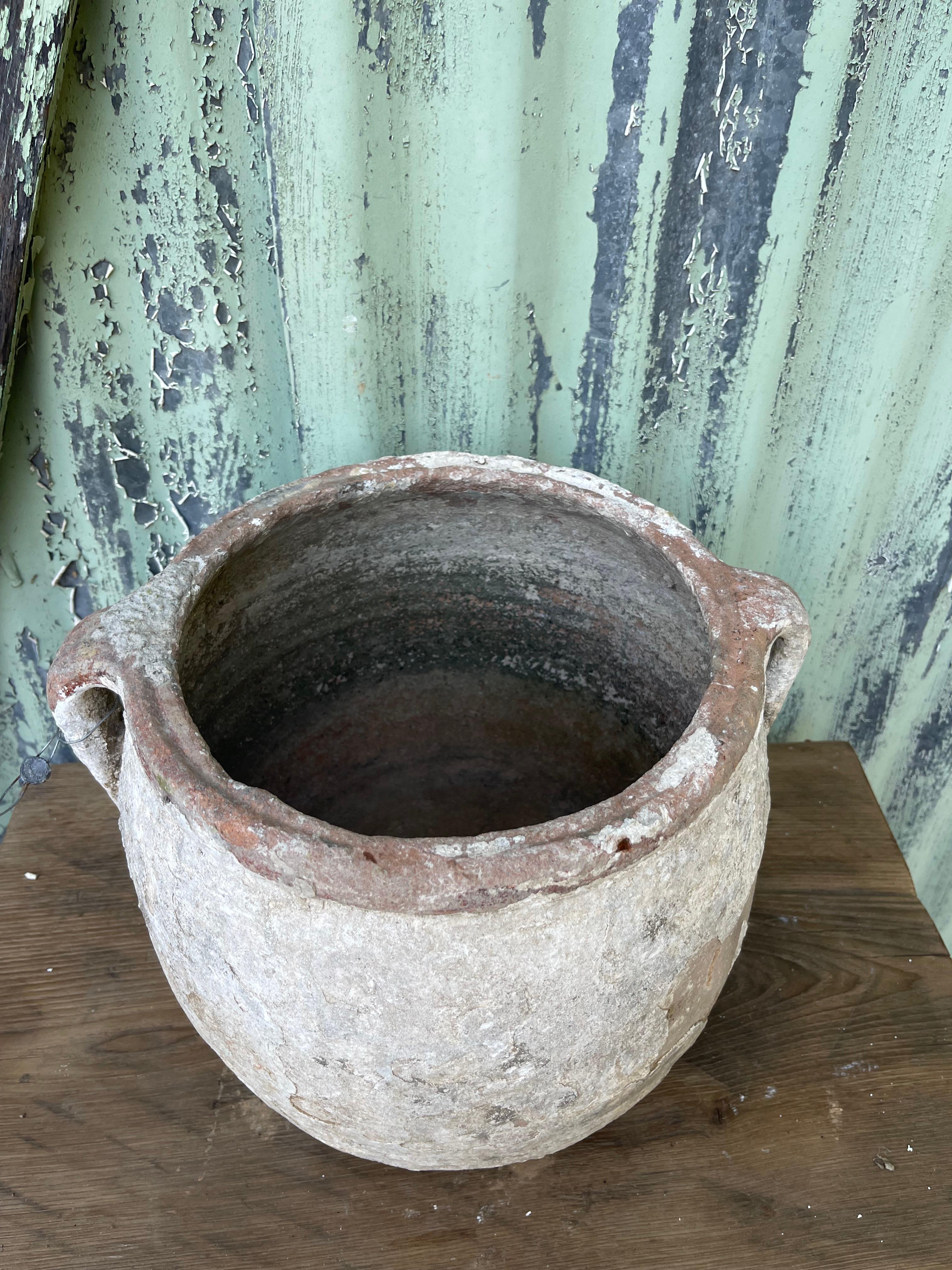 Questo piccolo vaso turco lavato a calce era probabilmente utilizzato in origine per conservare il burro e poi, alla fine, hanno iniziato a usare queste ciotole a bocca aperta per i fiori. Oggi, gli strati di calce su questo pezzo invitano la