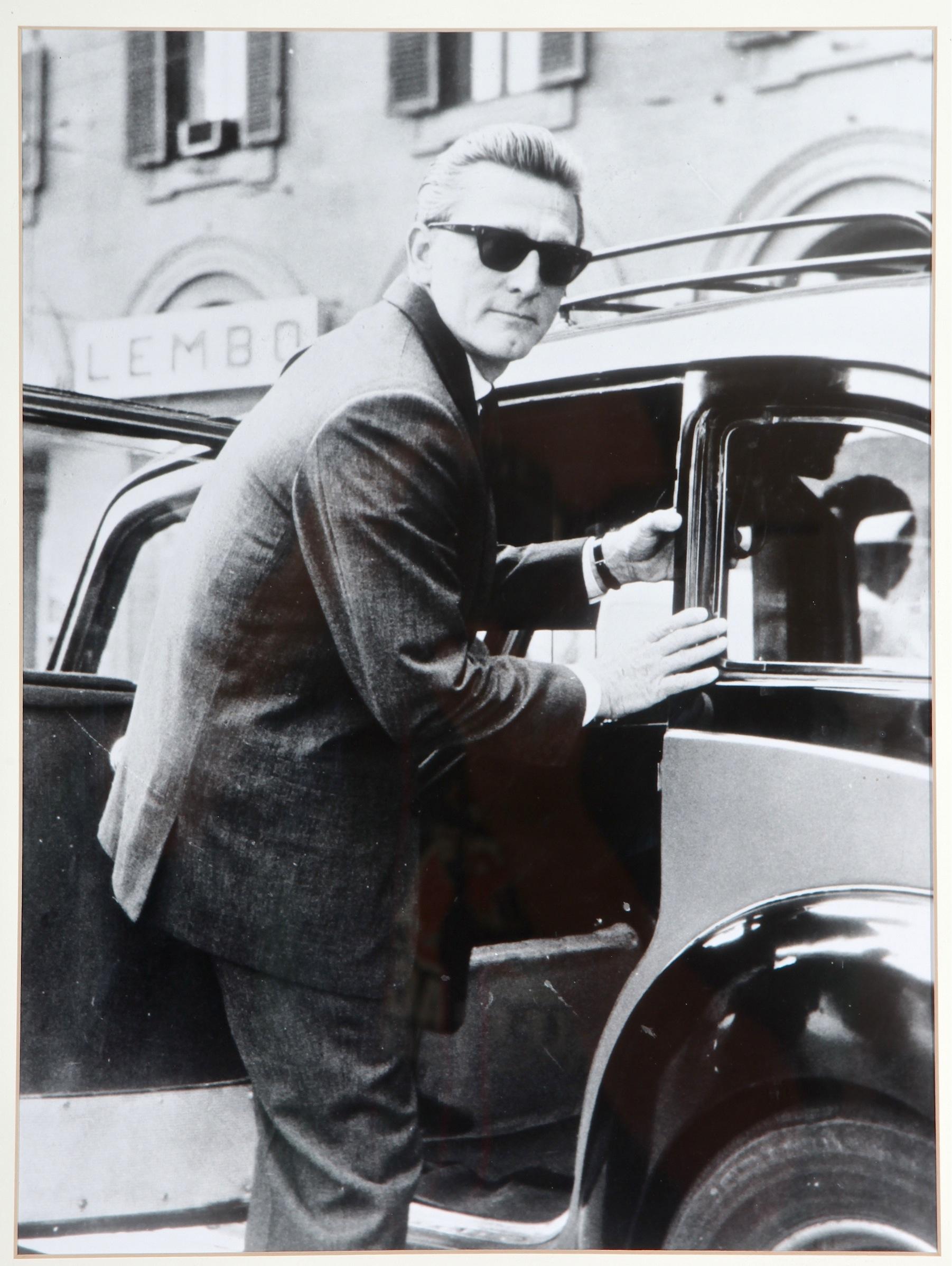 1960s black and white Italian paparazzi photo of Kirk Douglas. Attributed to Gian Colombo and is part of a paparazzi collection that includes Princess Grace, Audrey Hepburn, Elizabeth Taylor and Federico Fellini. Framed in a simple wood gallery