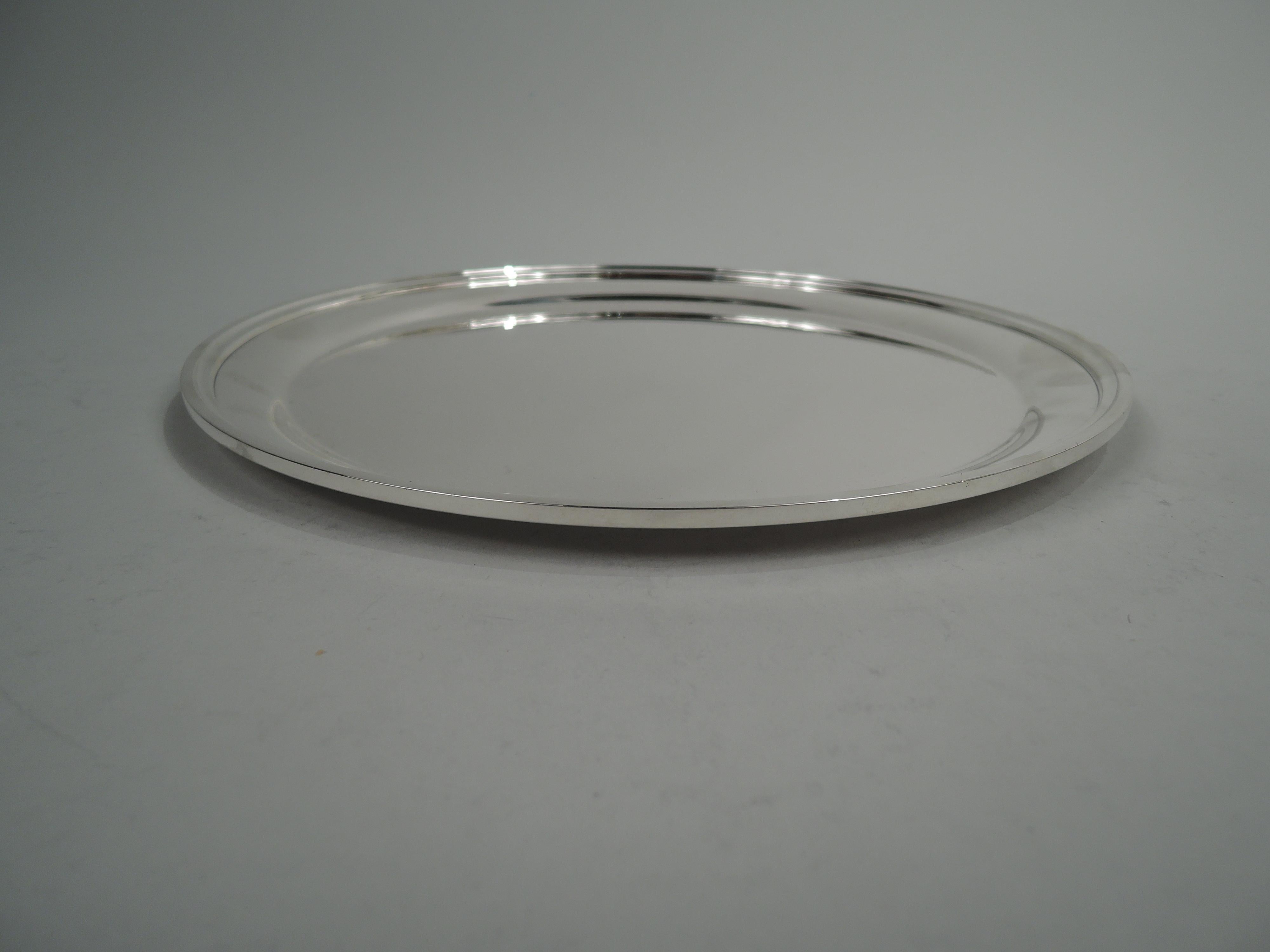 Midcentury Modern sterling silver tray. Made by S. Kirk & Son in Baltimore. Round with tapering shoulder and flat rectilinear rim. Fully marked including maker’s stamp (1932-61) and no. 4111. Heavy weight: 21 troy ounces. 