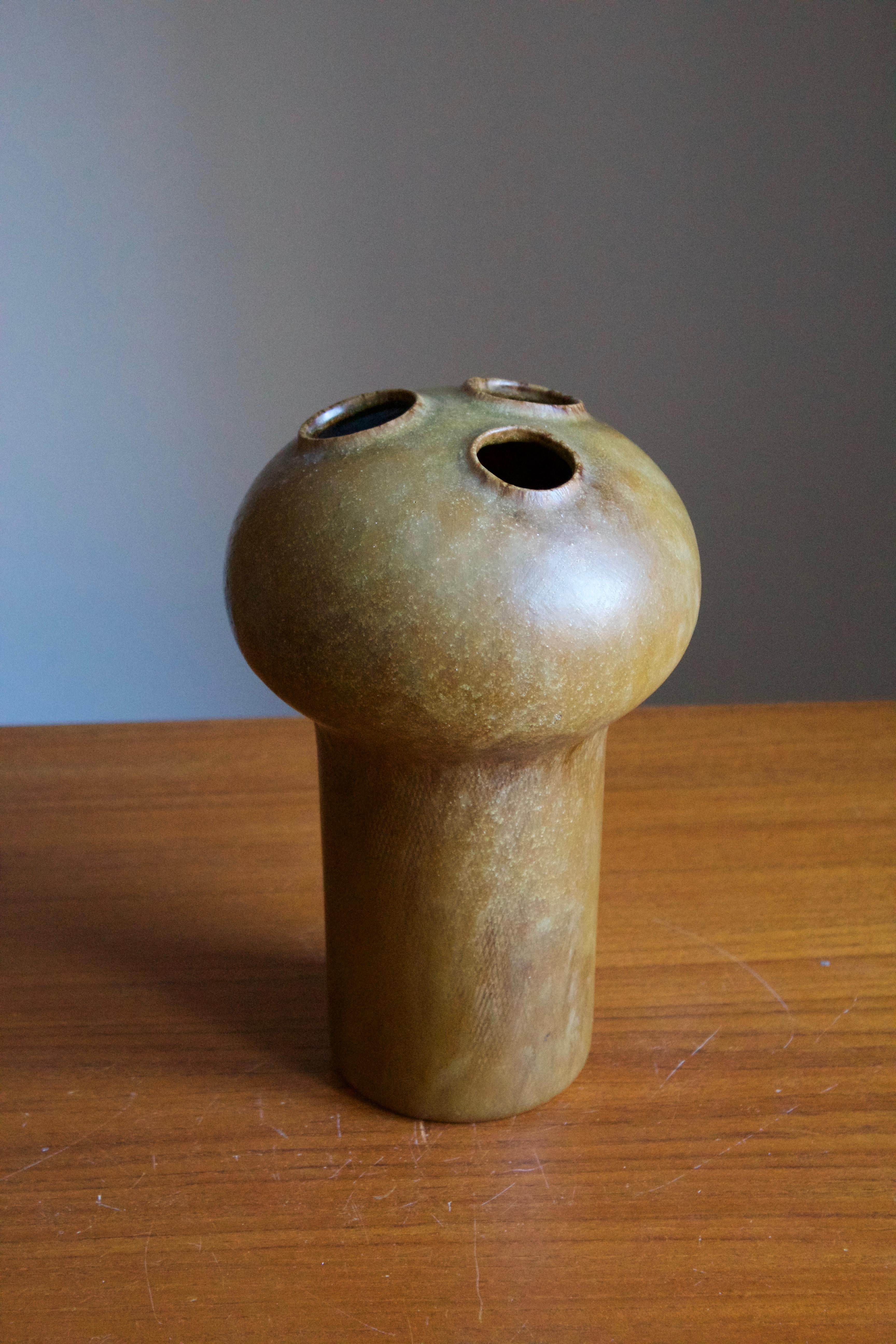 A flower vase, designed by Kirsten Günther and produced by Knabstrup, Denmark, c. 1972. stamped. Features subtle incised decor and green / brown glaze.

 
 