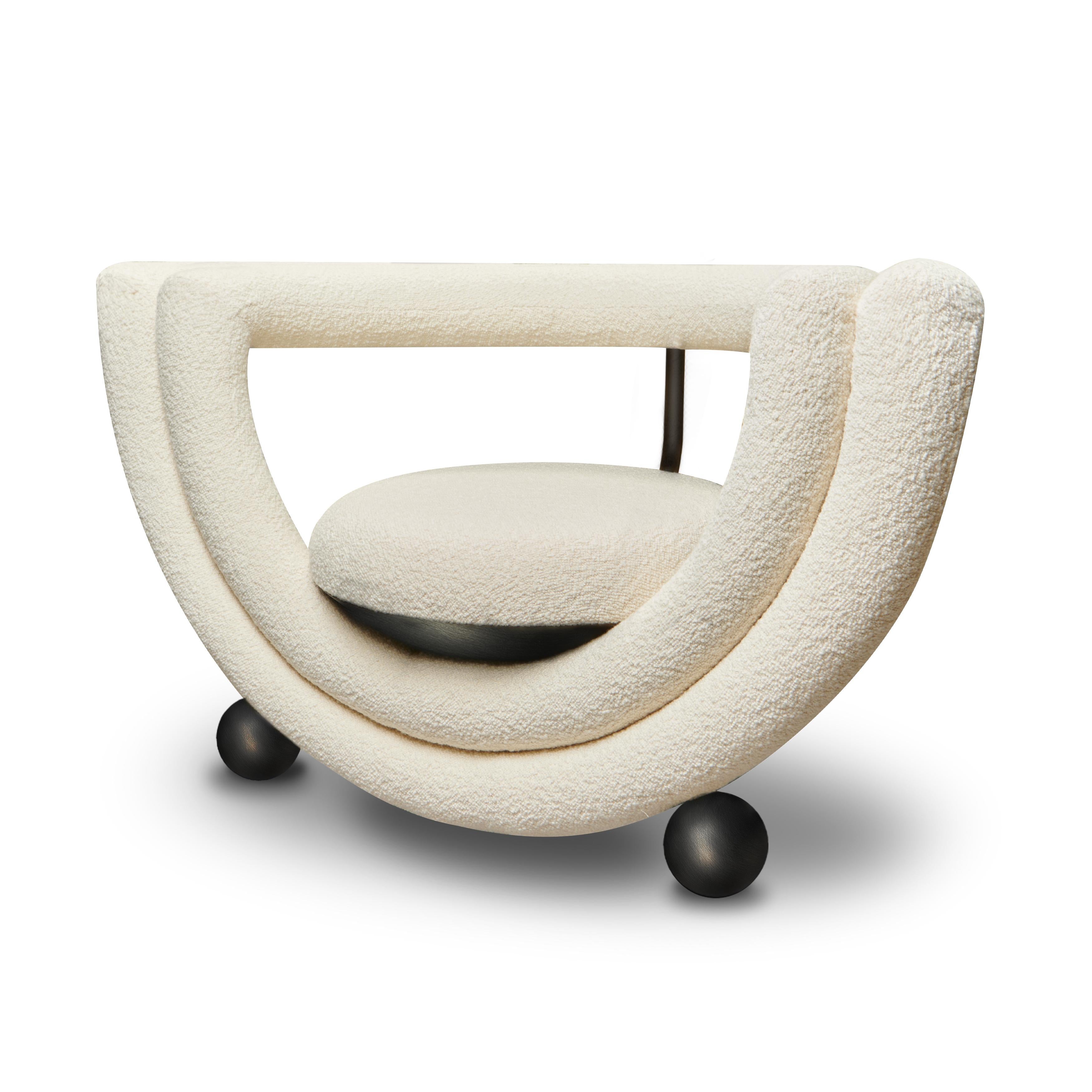 Kissing Armchair features two semi-circle layers; one bearing the cupped seat and a second forming the back-rest. All the lines are covered with soft upholstery apart from the metal legs and metal cups, which hold the upholstered seat like an ice