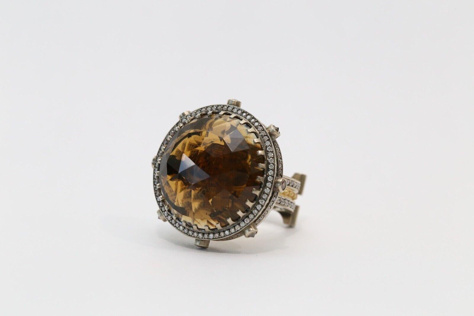 This striking KISUM ring showcases a bold design in 14k white and yellow gold. The architectural band features a central gold beaded channel framed by rows of white diamonds, adding texture and brilliance. The oversized smoky quartz is the