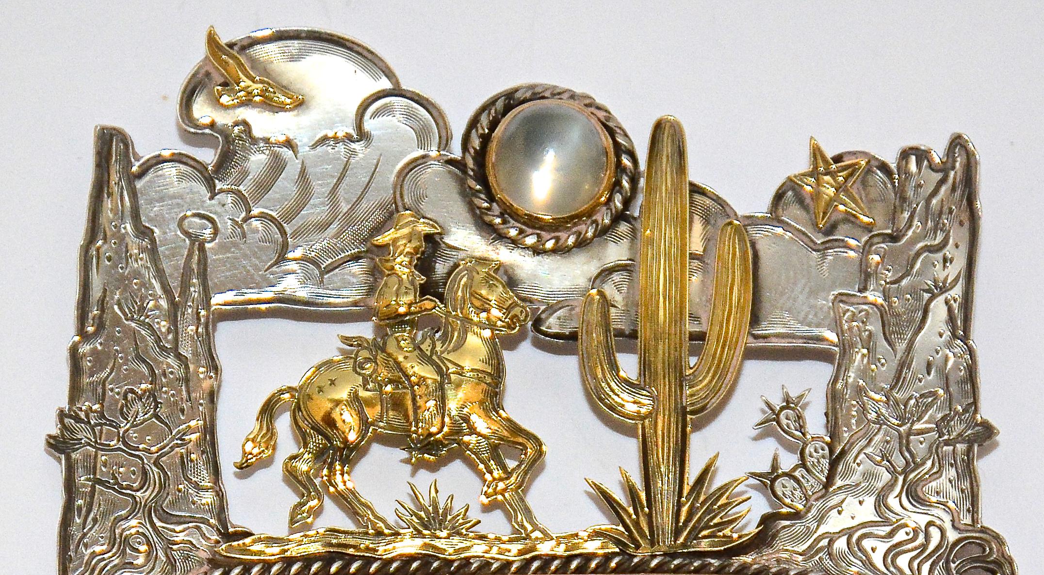 'Moonlight Ride' is an intricately engraved vintage art jewelry pin in sterling silver and 18k gold by renown jeweler and sculptor Kit Carson. 

This wonderful one-of-a-kind engraved narrative work depicting popular icons of the American Southwest