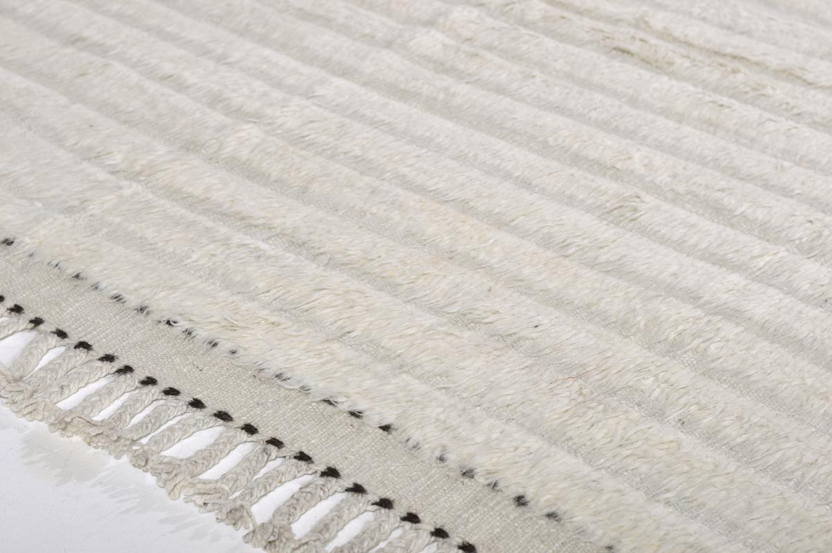 'Kit Moresby' has become an LA staple. The signature rug of Malibu. Handwoven of luxurious wool with timeless design elements. This Mehraban design is a contemporary interpretation of an Azilal with the perfect shade of white and embossed detailing,
