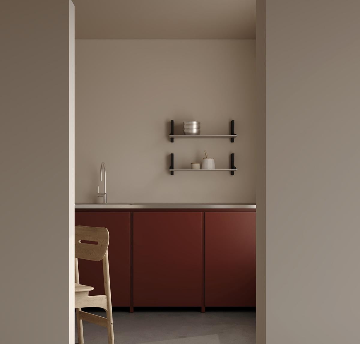 Una mensola aperta e montata a parete, progettata per riporre ed esporre oggetti di uso quotidiano. Realizzato in lamiera di alluminio grezza e staffe in legno di culatta con finitura a base d'acqua color nero carbone, il suo design semplicistico e