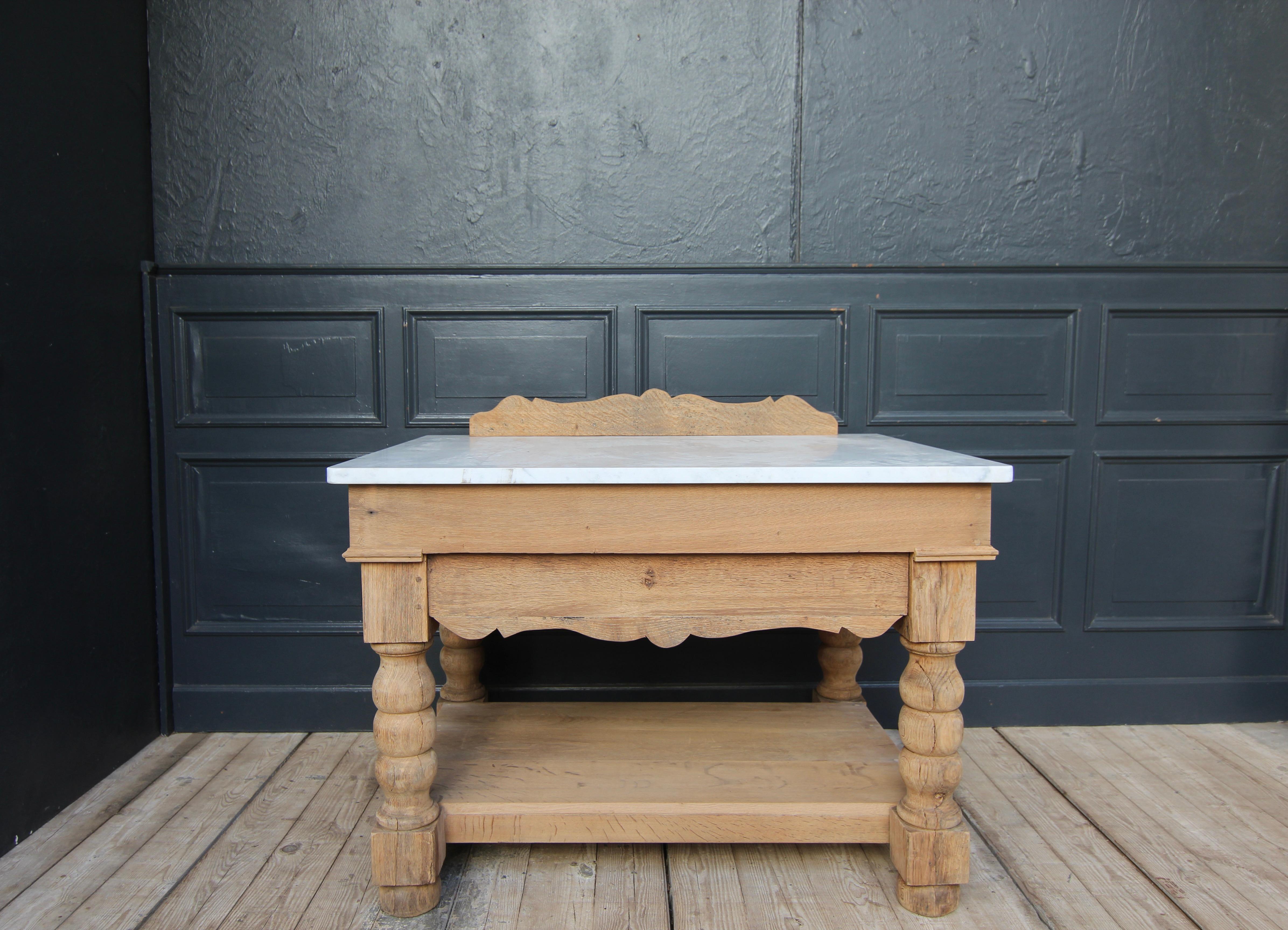 A 19th Century stripped oak table with a later added marble plate. Perfect as a kitchen worktable or kitchen island. 

Consisting of an old oak frame and a top made of Carrara marble. In the rectangular table frame with strong turned legs and high