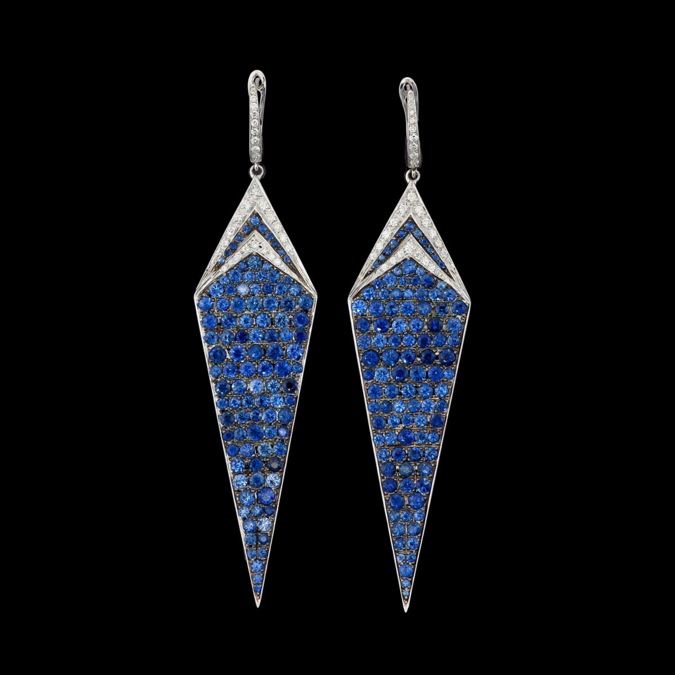 Une étonnante paire de boucles d'oreilles en saphir en or blanc 18 carats, présentant une silhouette géométrique audacieuse et une qualité de fabrication exceptionnelle. Les boucles d'oreilles présentent un pavage précis de saphirs bleus vifs dans