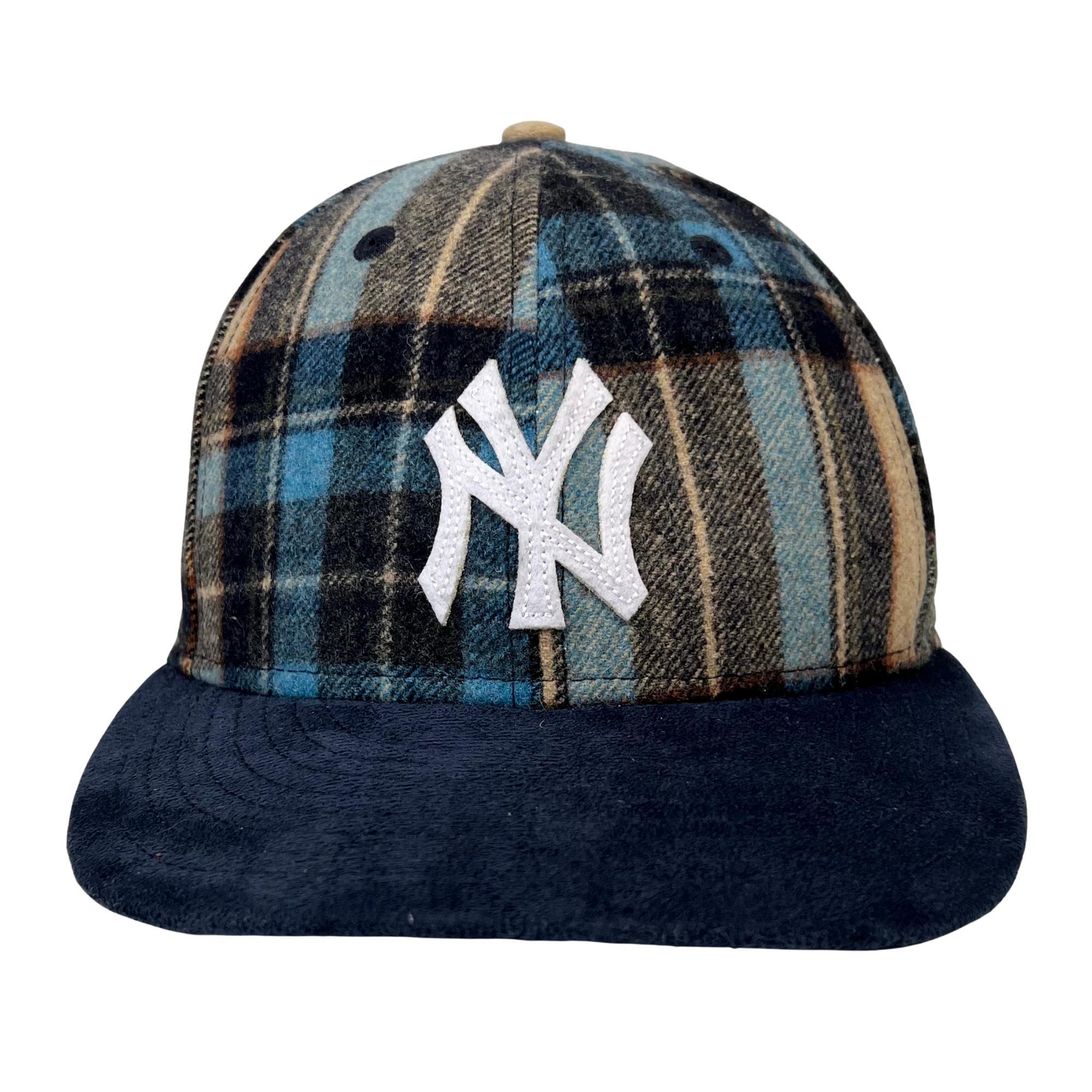 This hat is made with plaid wool fabric and features a sueded brim, an embroidered NY Yankees patch at front,
A New Era logo, a world series artworks embroidered at sides and a metal Kith & Kin plaque at