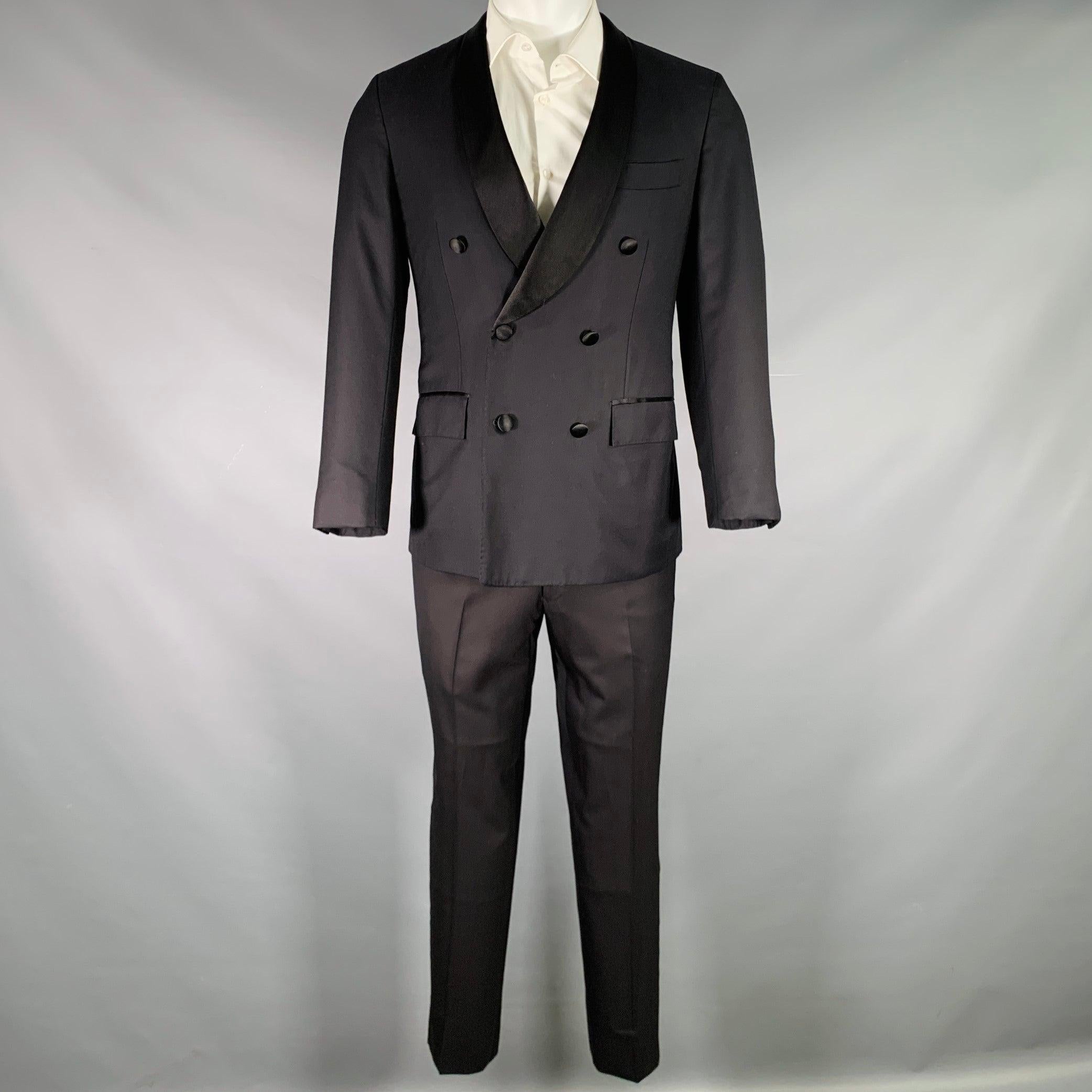 KITON-Smoking
aus schwarzer Wolle mit vollem Futter, bestehend aus einem doppelreihigen Sportmantel mit Schalrevers, einer doppelreihigen Weste mit Schalrevers und einer passenden Hose mit flacher Front. Hergestellt in Italien. Hinweis: Die Ärmel