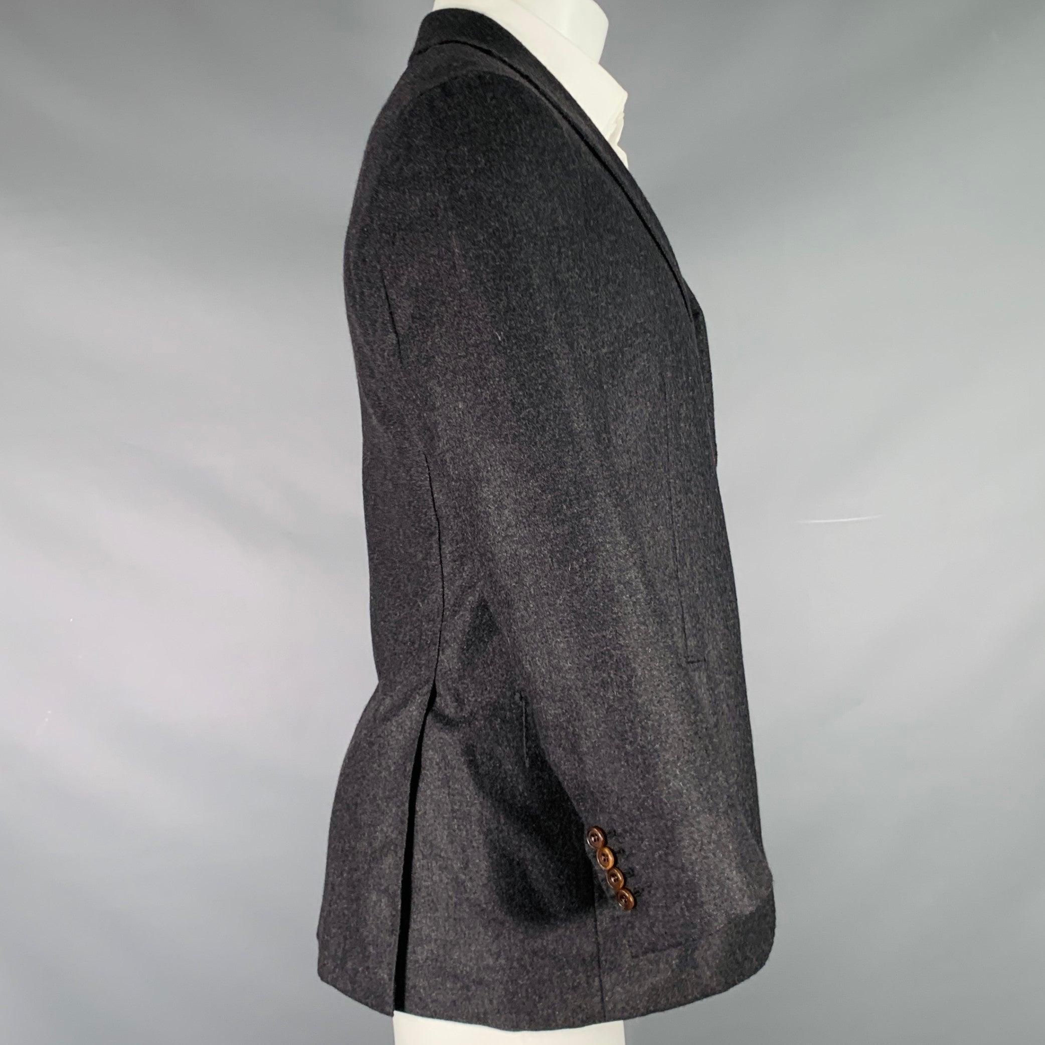 KITON per il cappotto sportivo Wilkes Bashford
in tessuto grigio antracite, con revers a lancia, doppio spacco sul retro e chiusura a due bottoni. Made in Italy. Eccellente condizione di usato. 

Contrassegnato:   47 

Misure: 
 
Spalla: 17 pollici